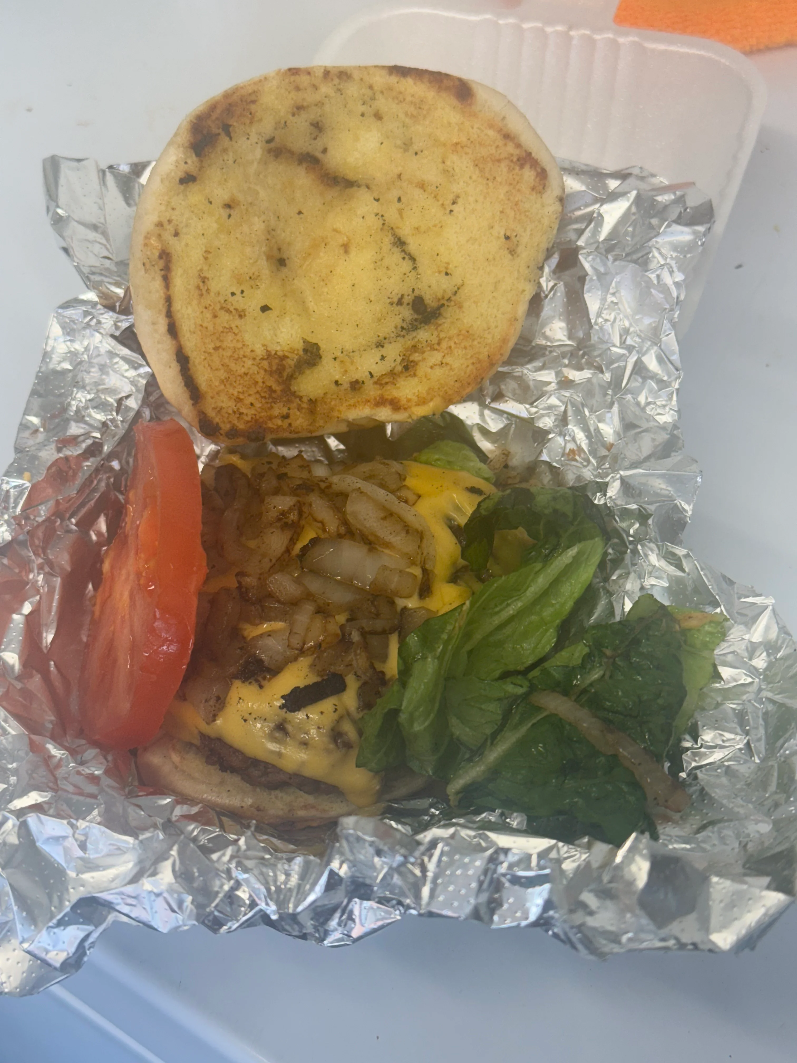Juicy cheeseburger with grilled onions and fresh toppings