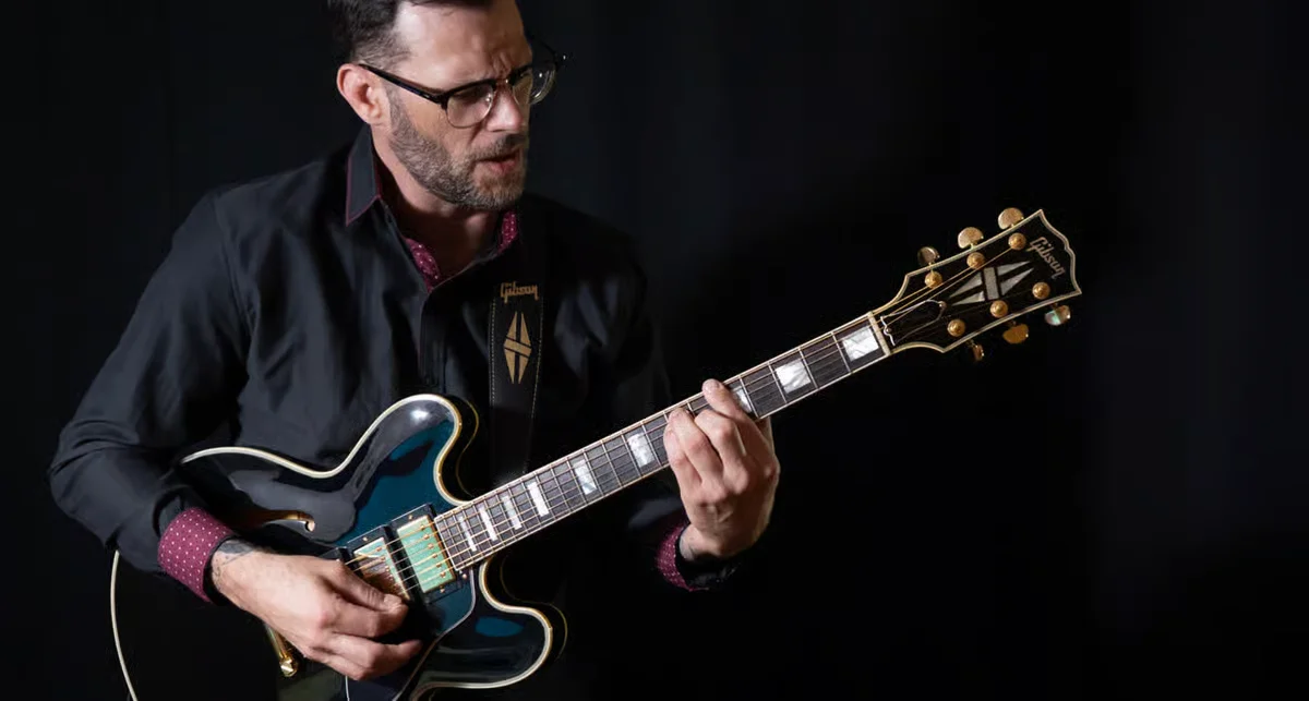 Musician passionately playing guitar against a dark backdrop