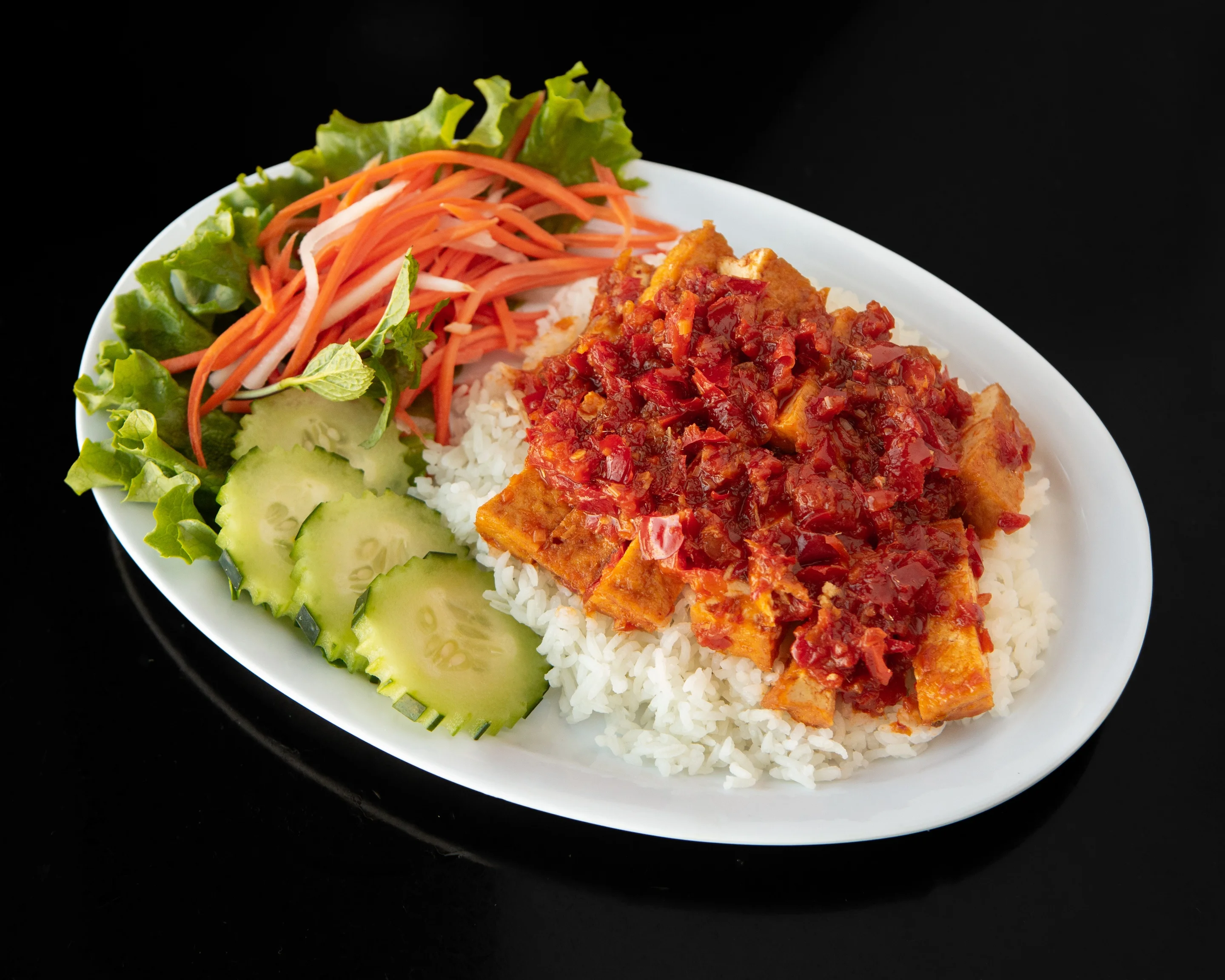 Vietnamese rice dish with spicy tofu and fresh vegetables