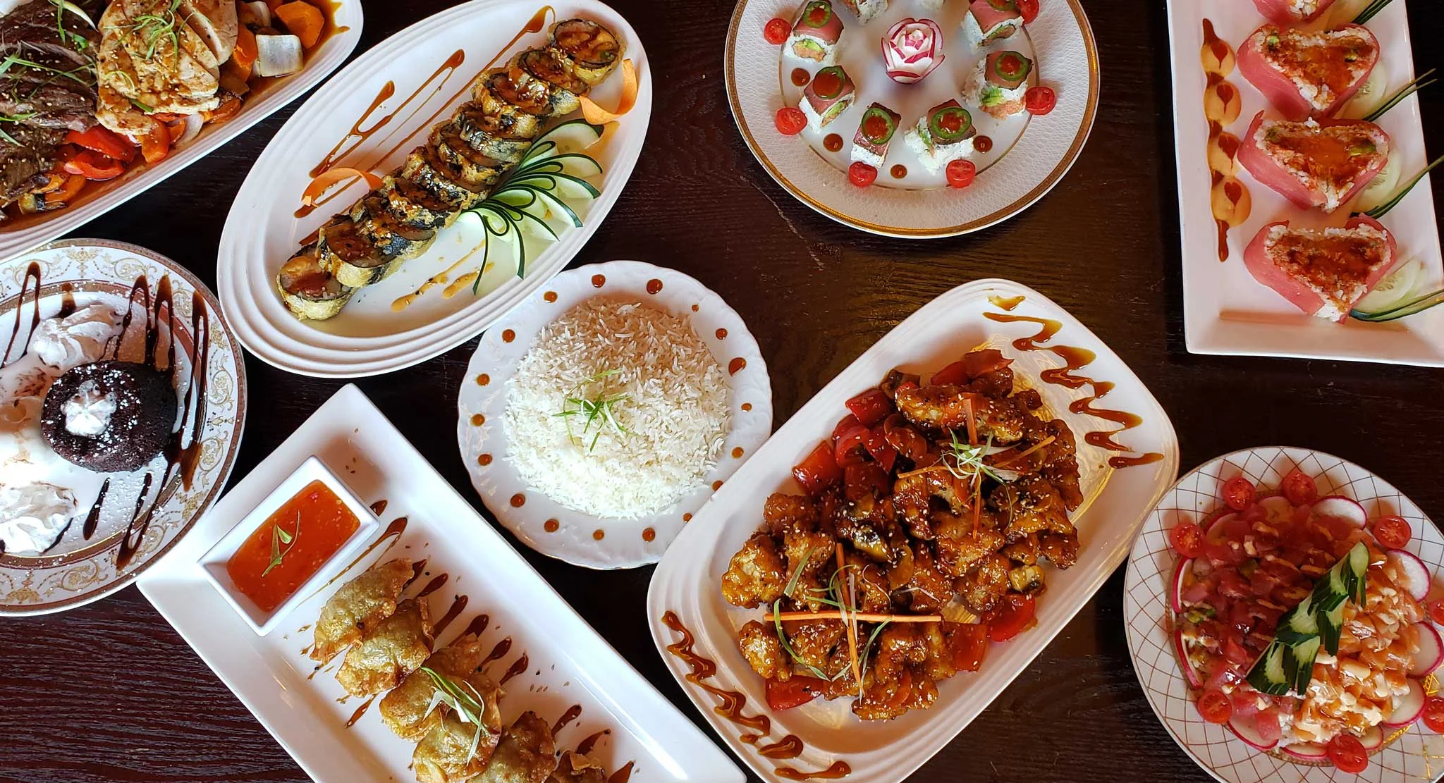 Assorted Asian fusion dishes including sushi and sweet and sour chicken