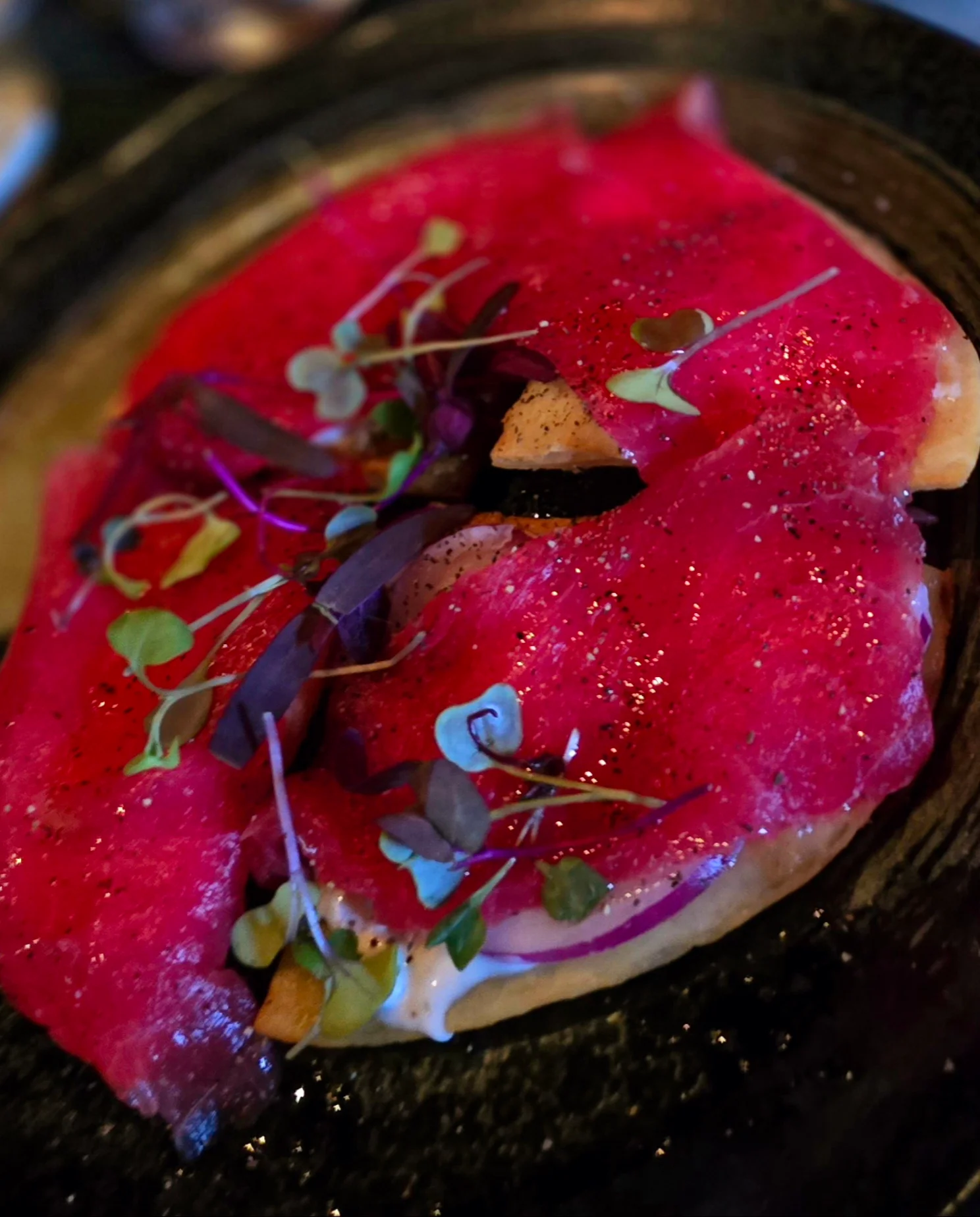 Japanese sashimi with vibrant toppings on a black plate