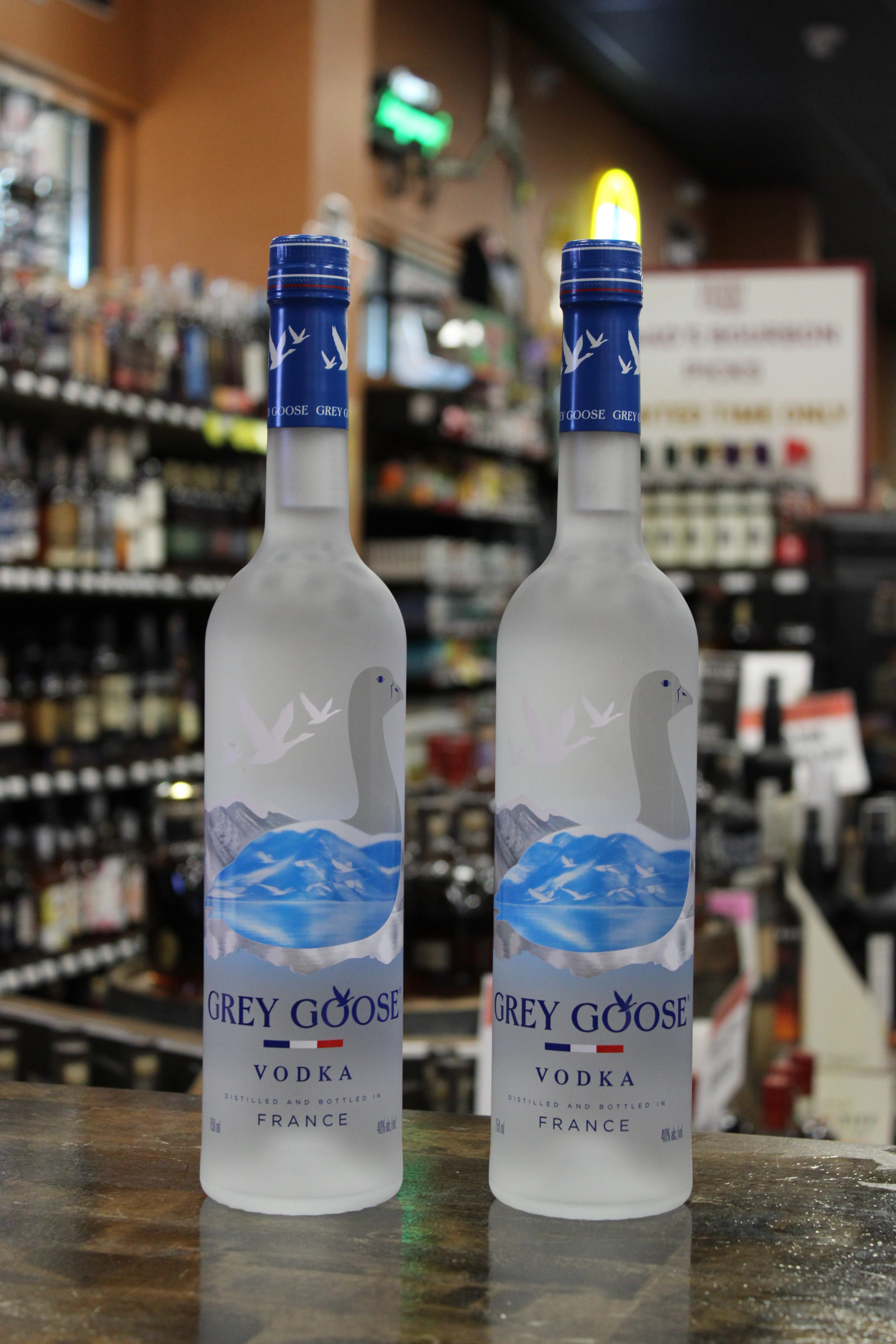 Two bottles of Grey Goose vodka on a bar counter