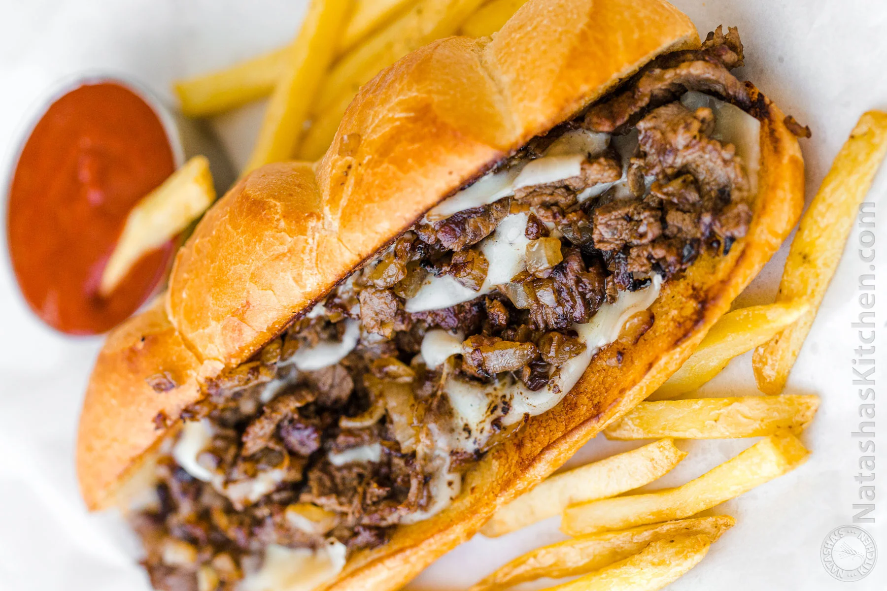 Philly cheesesteak sandwich with fries and marinara sauce