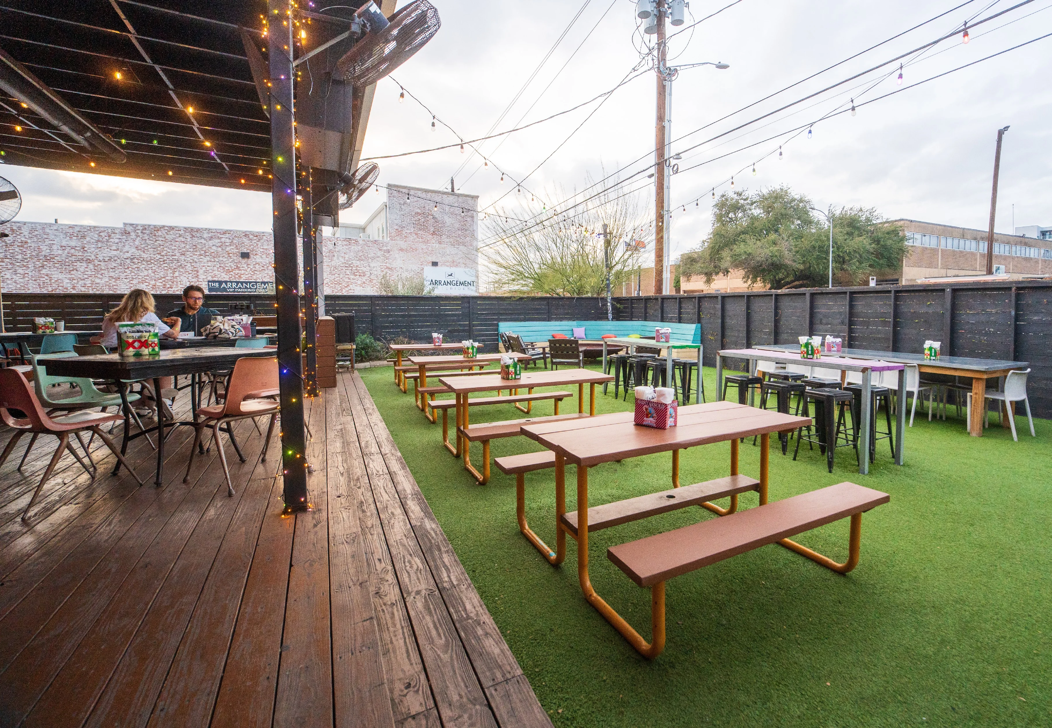 Outdoor dining area with colorful seating and string lights
