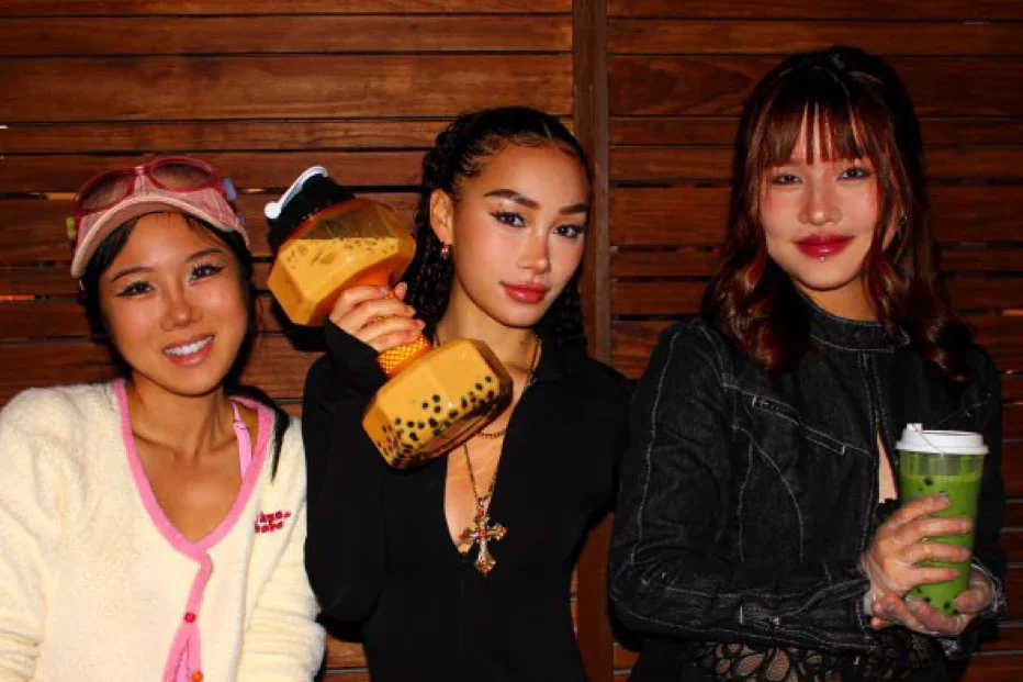 Three friends posing with playful props in a cozy setting