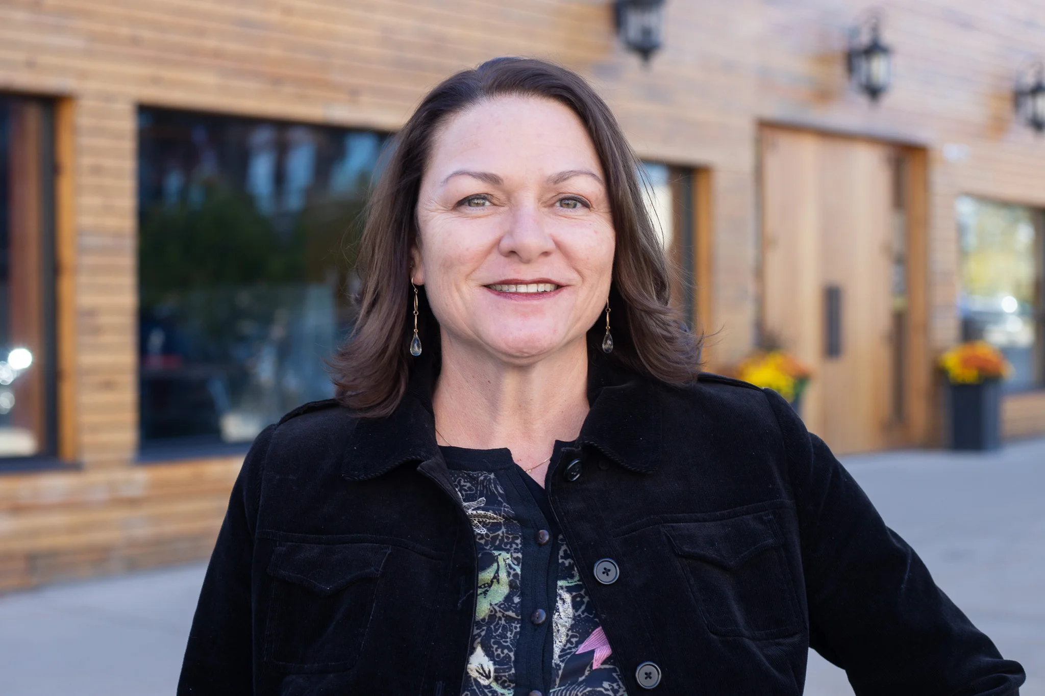 Smiling woman in front of a modern restaurant exterior
