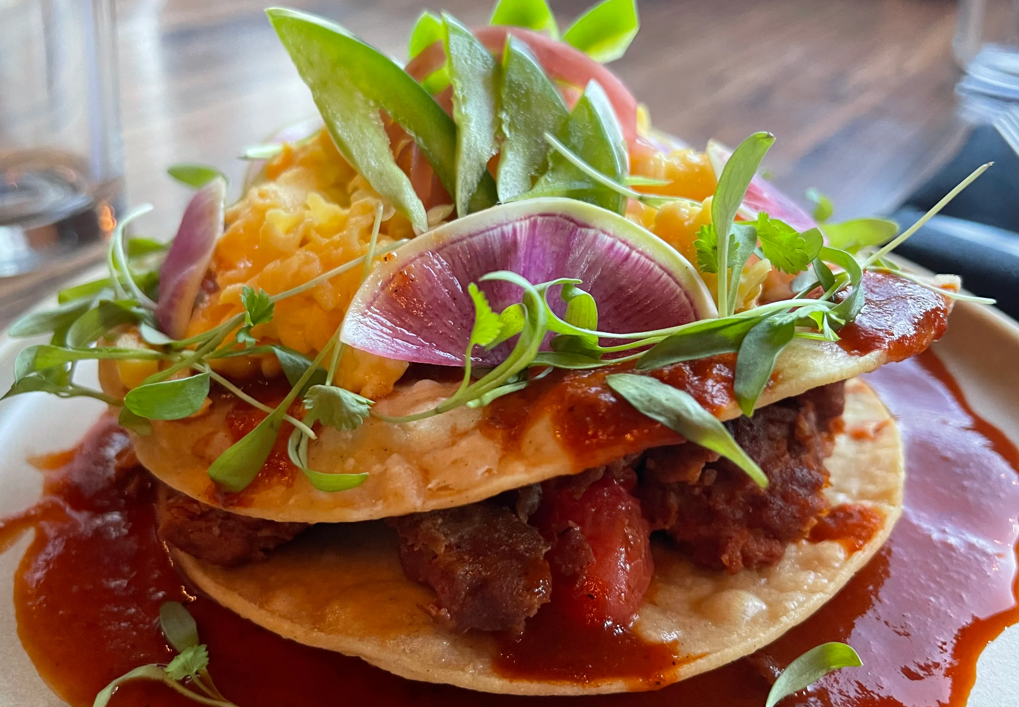 Mexican tostada topped with savory ingredients and fresh garnishes
