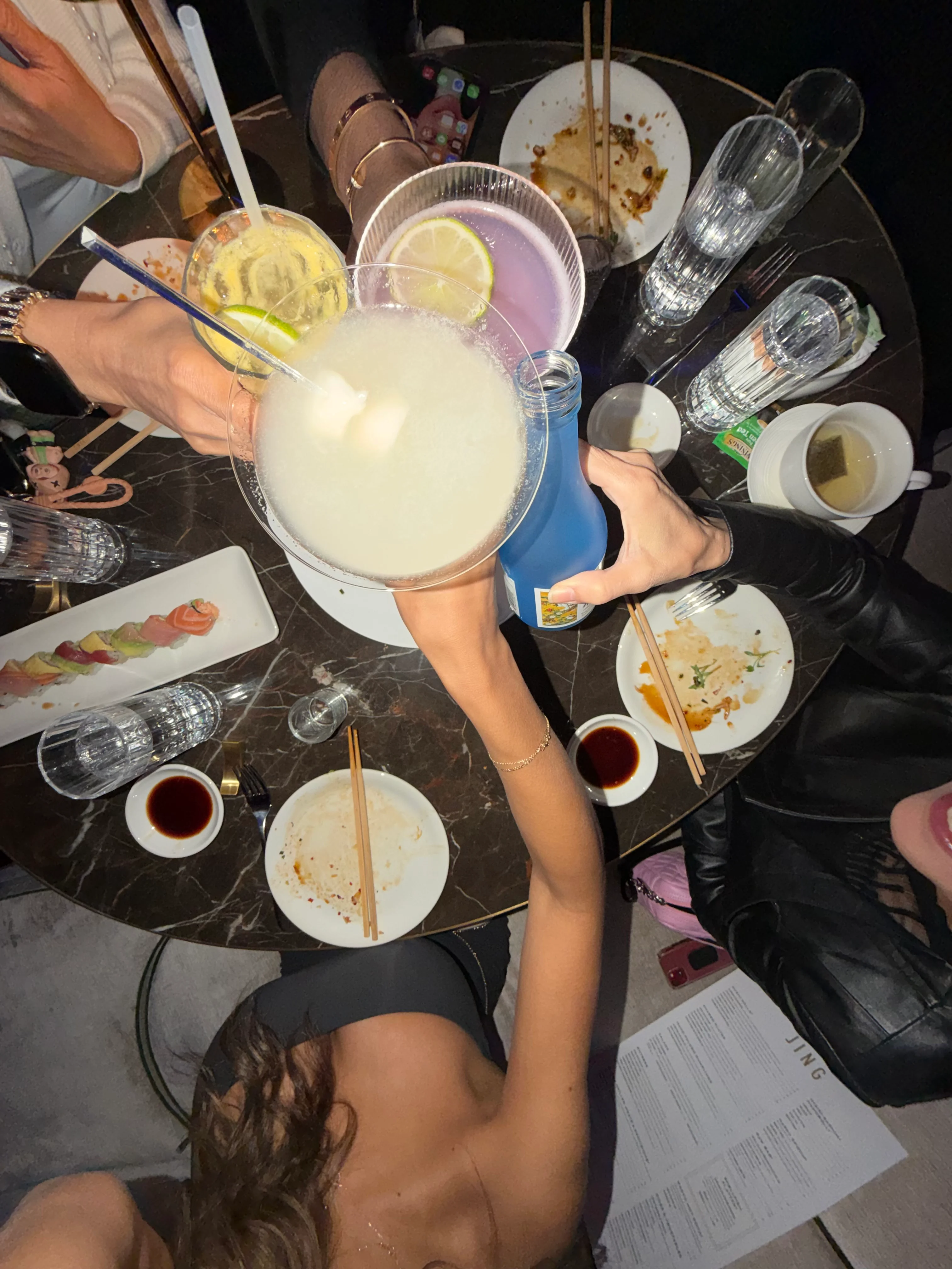 Cheers with colorful cocktails at a lively dining table