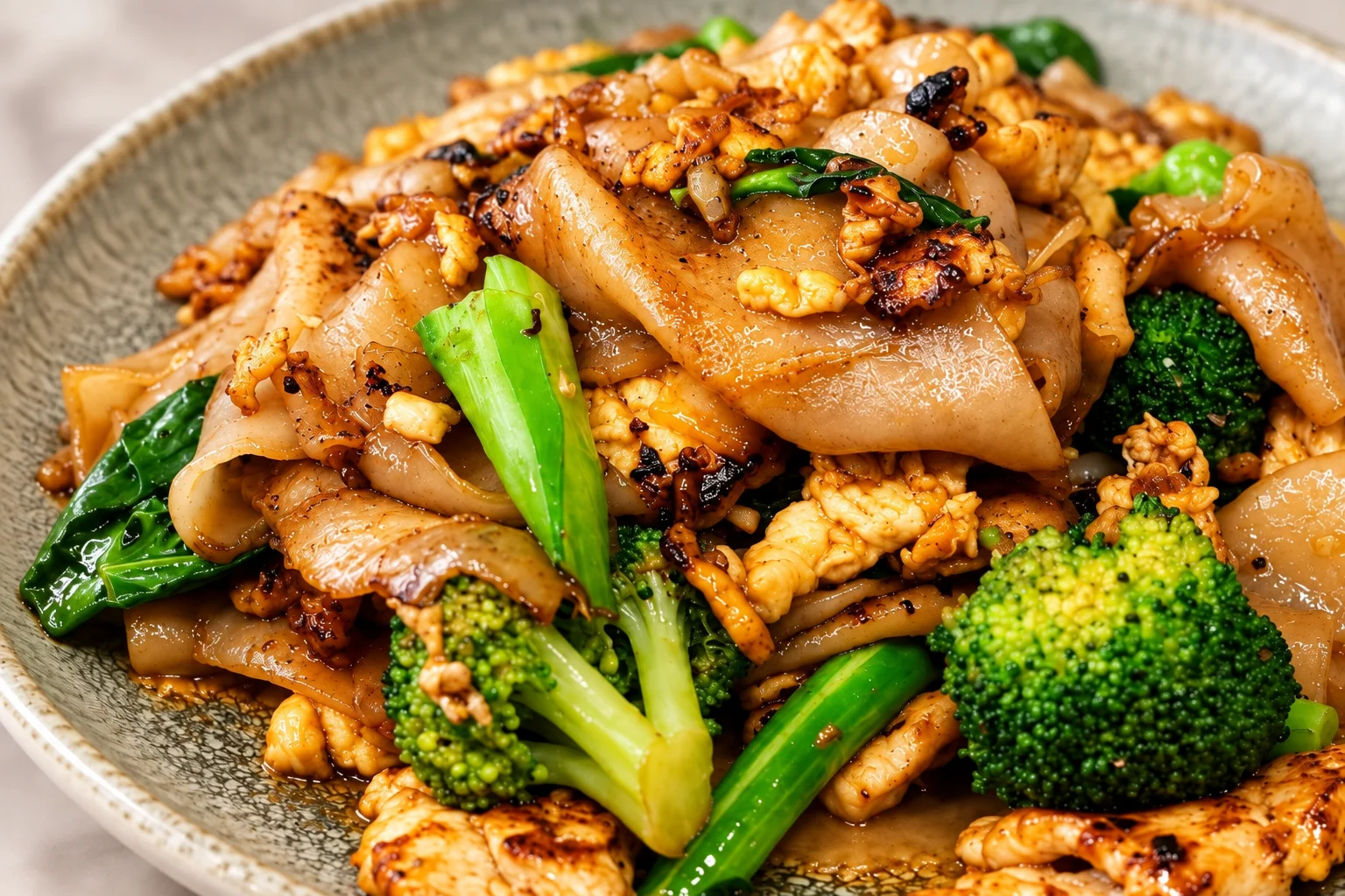 Pad See Ew with chicken, wide rice noodles, egg, and broccoli