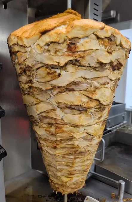 Vertical shawarma cone roasting on a spit