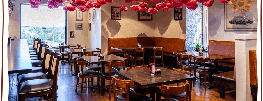 Cozy restaurant interior with colorful hanging decorations and wooden furniture