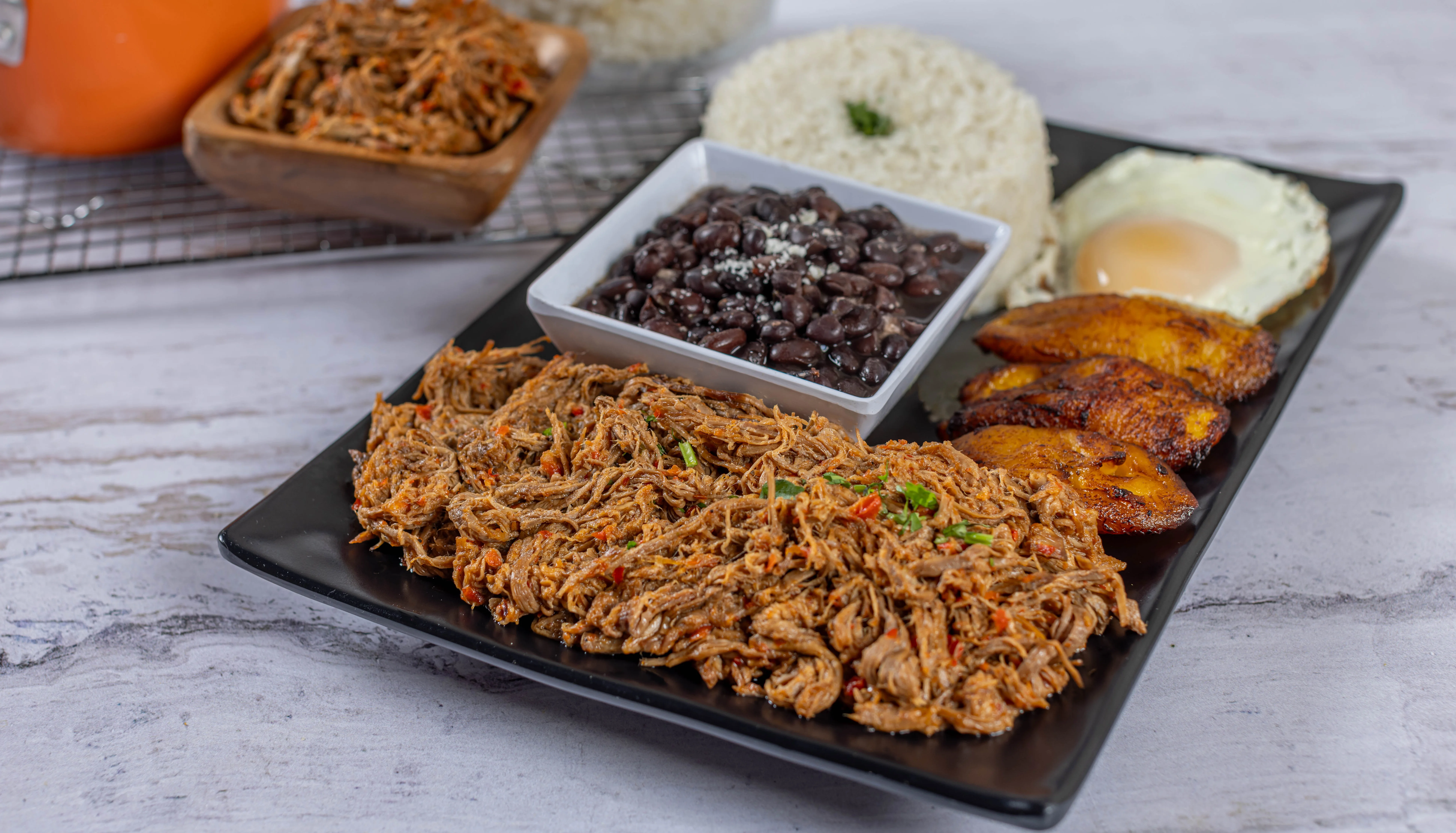 The Pabellón Criollo, Venezuela's national dish, featuring shredded beef, black beans, white rice, and sweet plantains, served at El Budare Cafe.