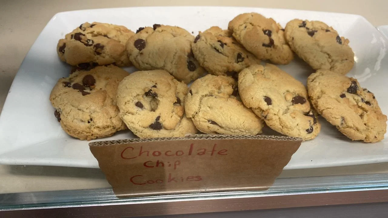 A plate of freshly baked chocolate chip cookies arranged neatly. The cookies are golden brown with chocolate chips visible on the surface.