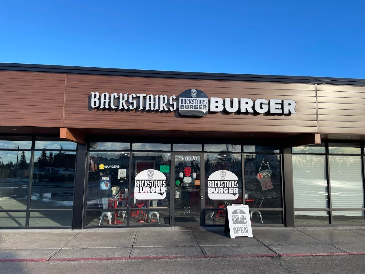 Exterior view of Backstairs Burger restaurant with open sign
