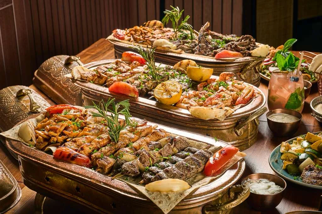 Mediterranean halal spread with grilled meats, rice, salads, and fresh pita served at Sufrat Grill in Miami.