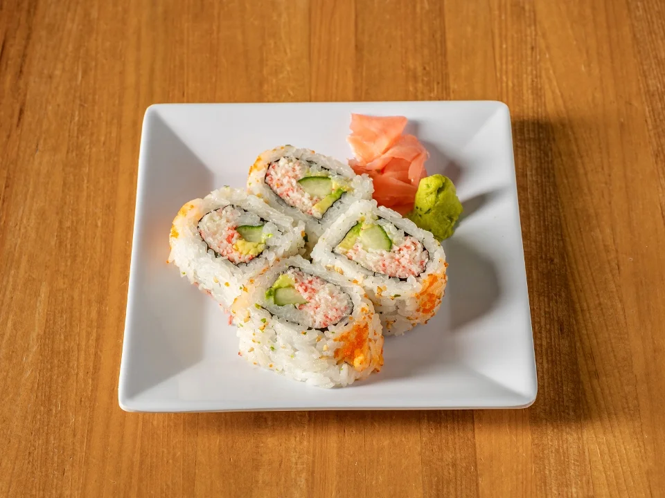 A neatly arranged plate of sushi rolls filled with crab and cucumber, served with wasabi and pickled ginger.