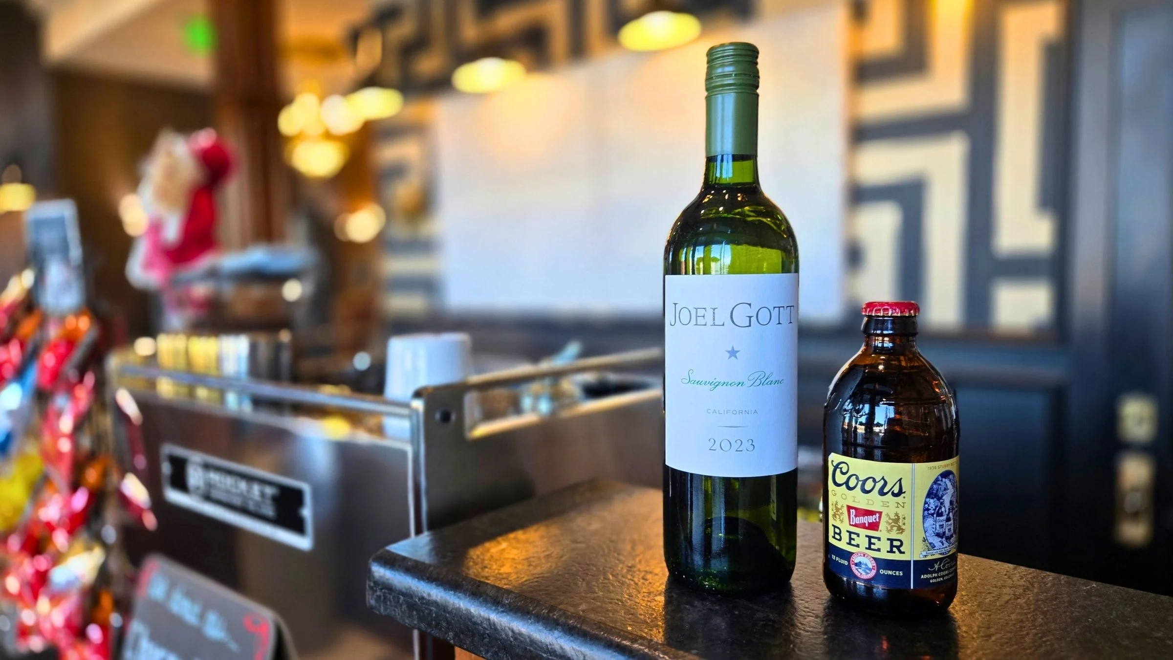 Bottle of Sauvignon Blanc and Coors beer on a bar counter
