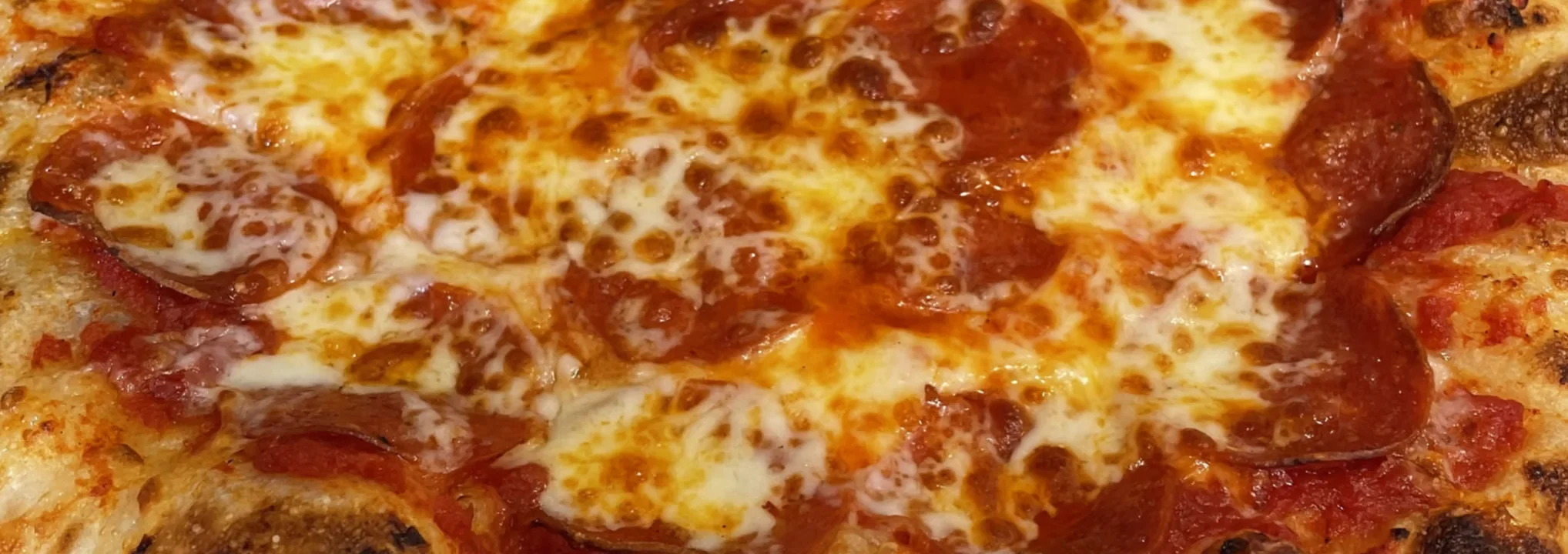 Pepperoni pizza with melted cheese from a wood-fired oven