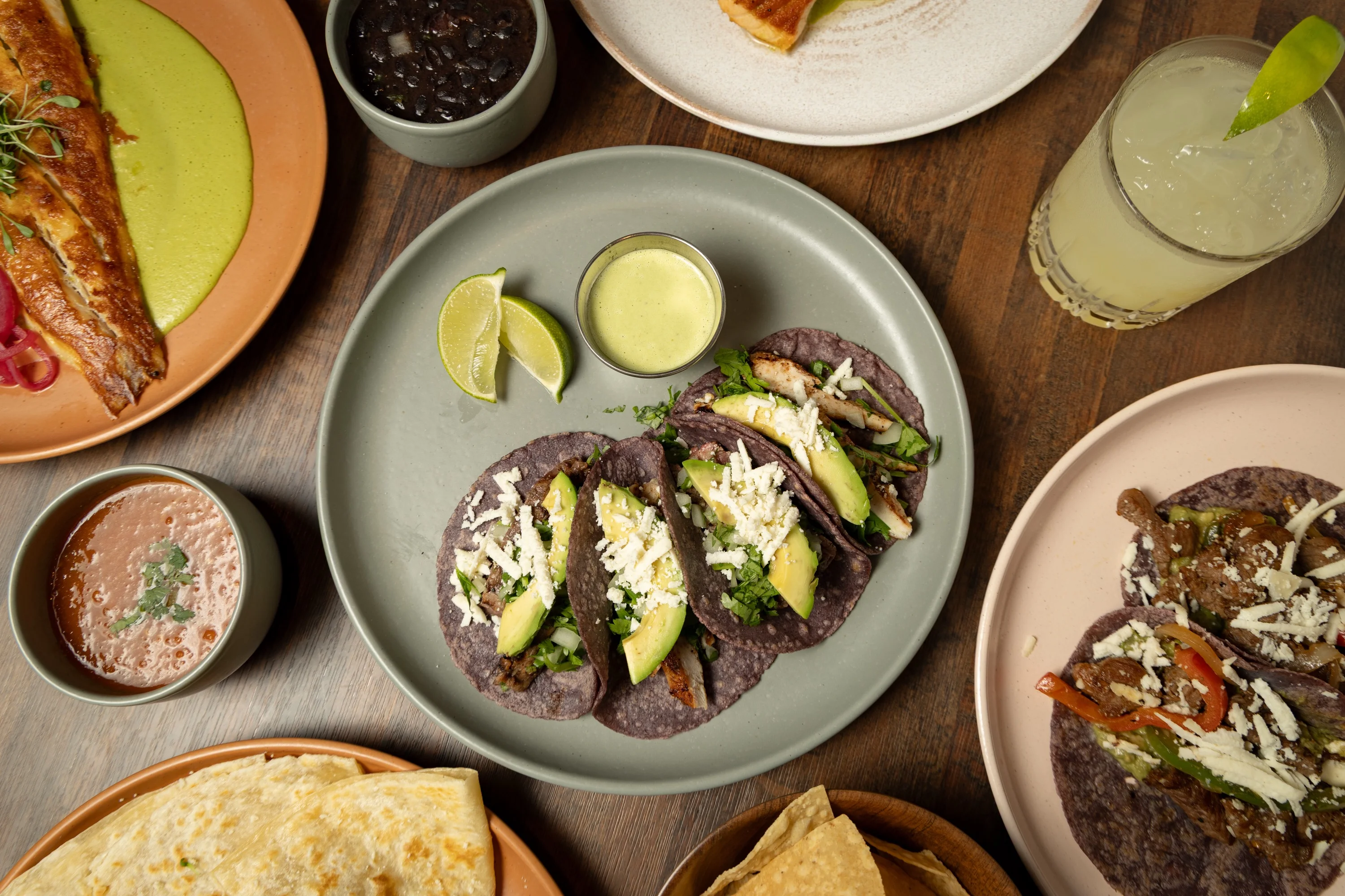 Colorful plate of Mexican tacos with avocado and lime wedges