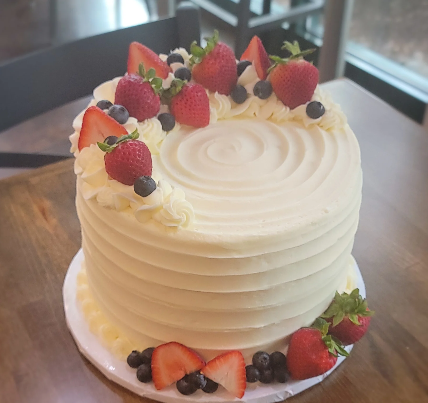 Classic vanilla cake topped with fresh strawberries and blueberries