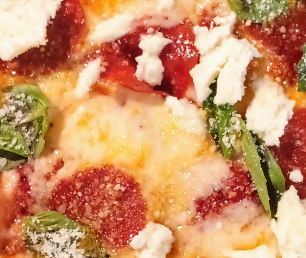Pepperoni pizza with fresh basil and ricotta