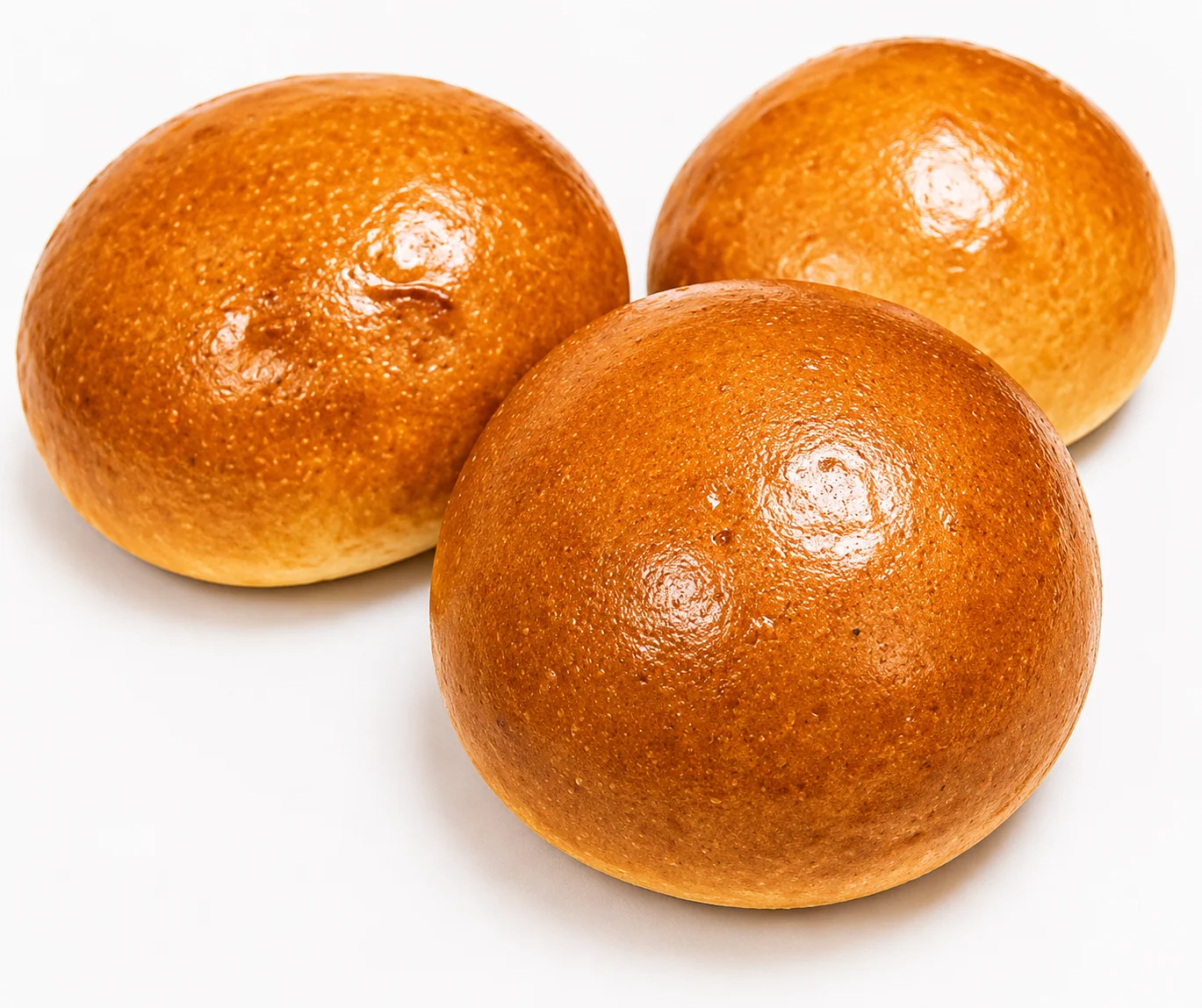 Three golden-brown round pastries on a white background.