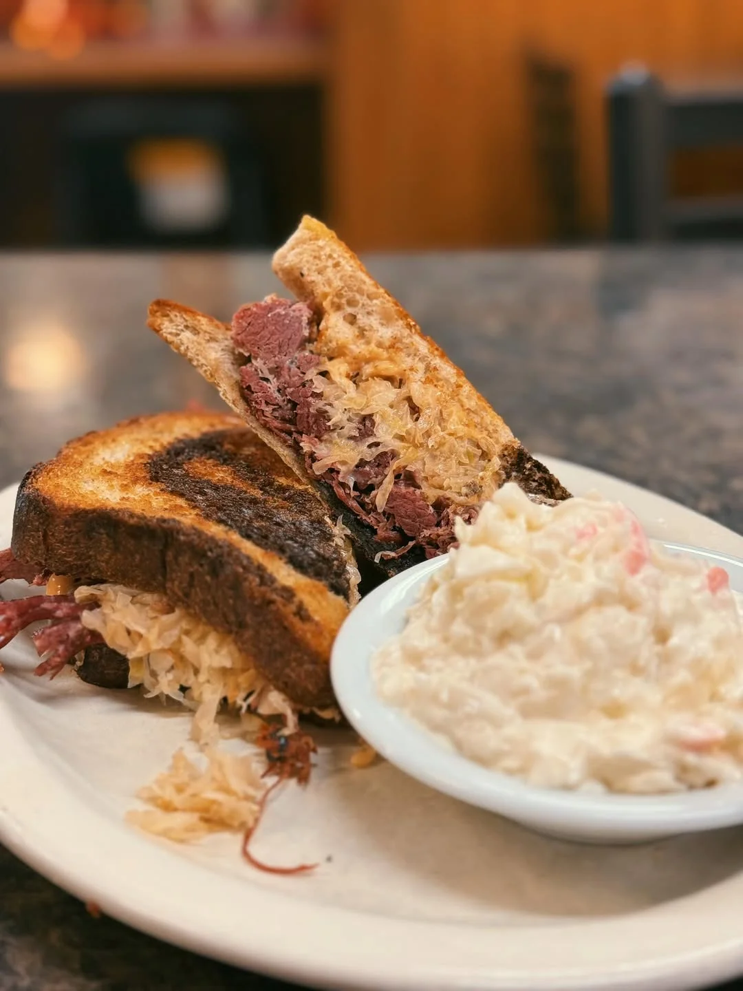 Classic Reuben sandwich with sauerkraut and side of coleslaw