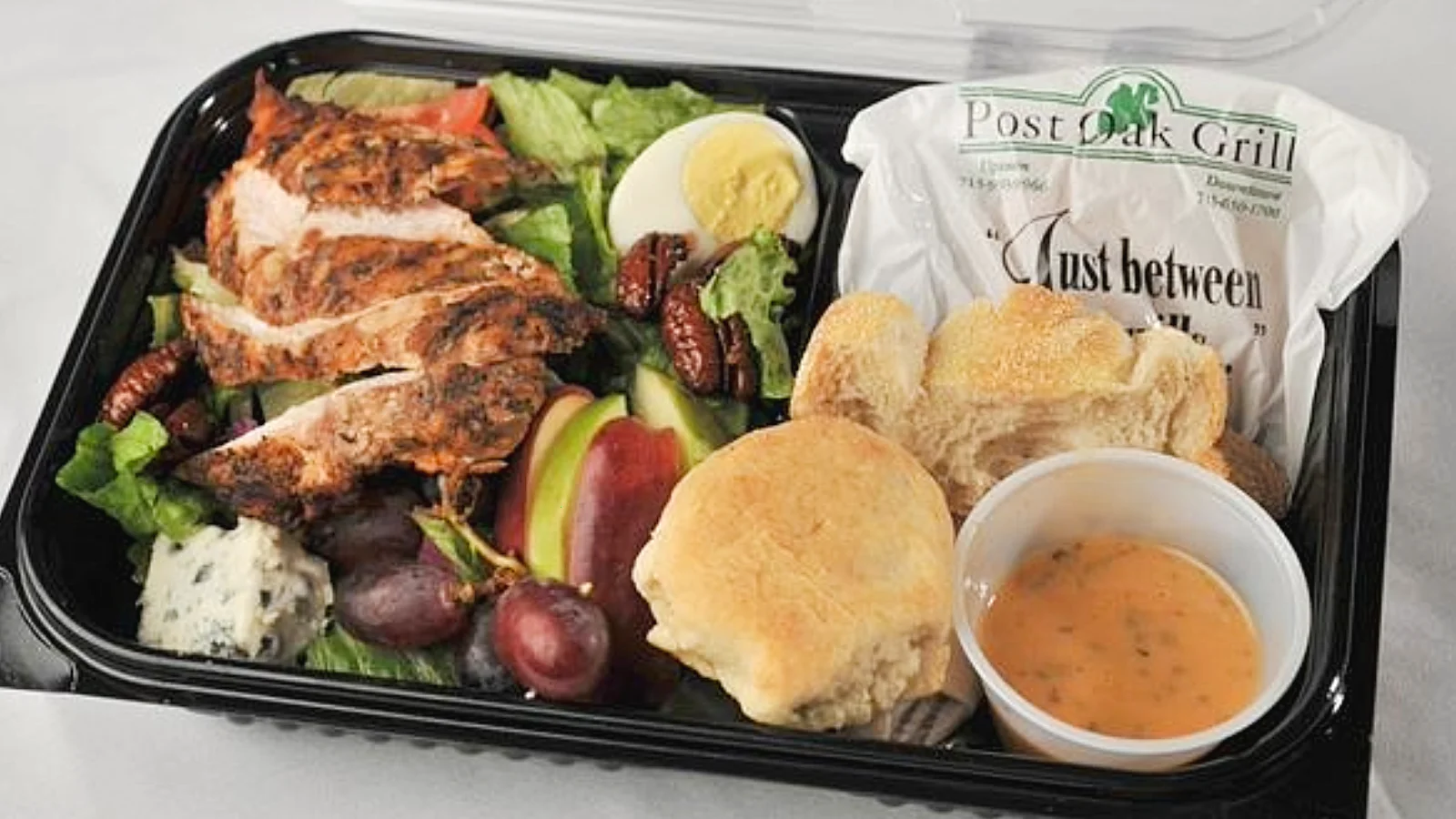 Warm grilled chicken salad with mixed greens, tomatoes, apples, blue cheese, and boiled egg at Post Oak Grill Downtown Houston.