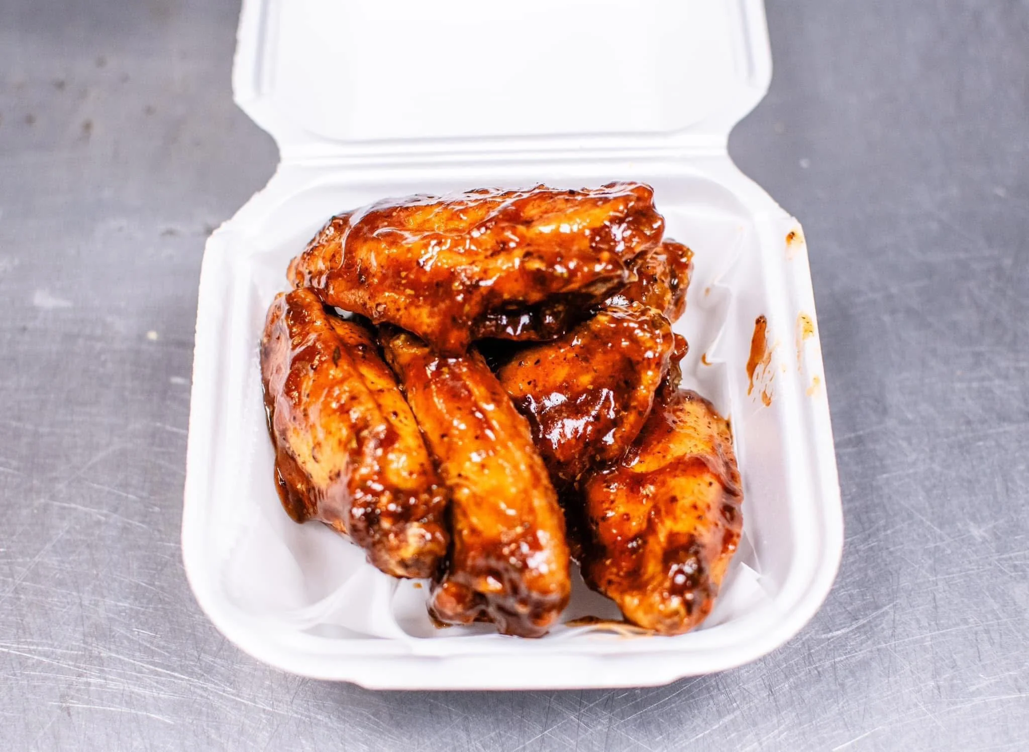 Savory BBQ chicken wings in a takeout container