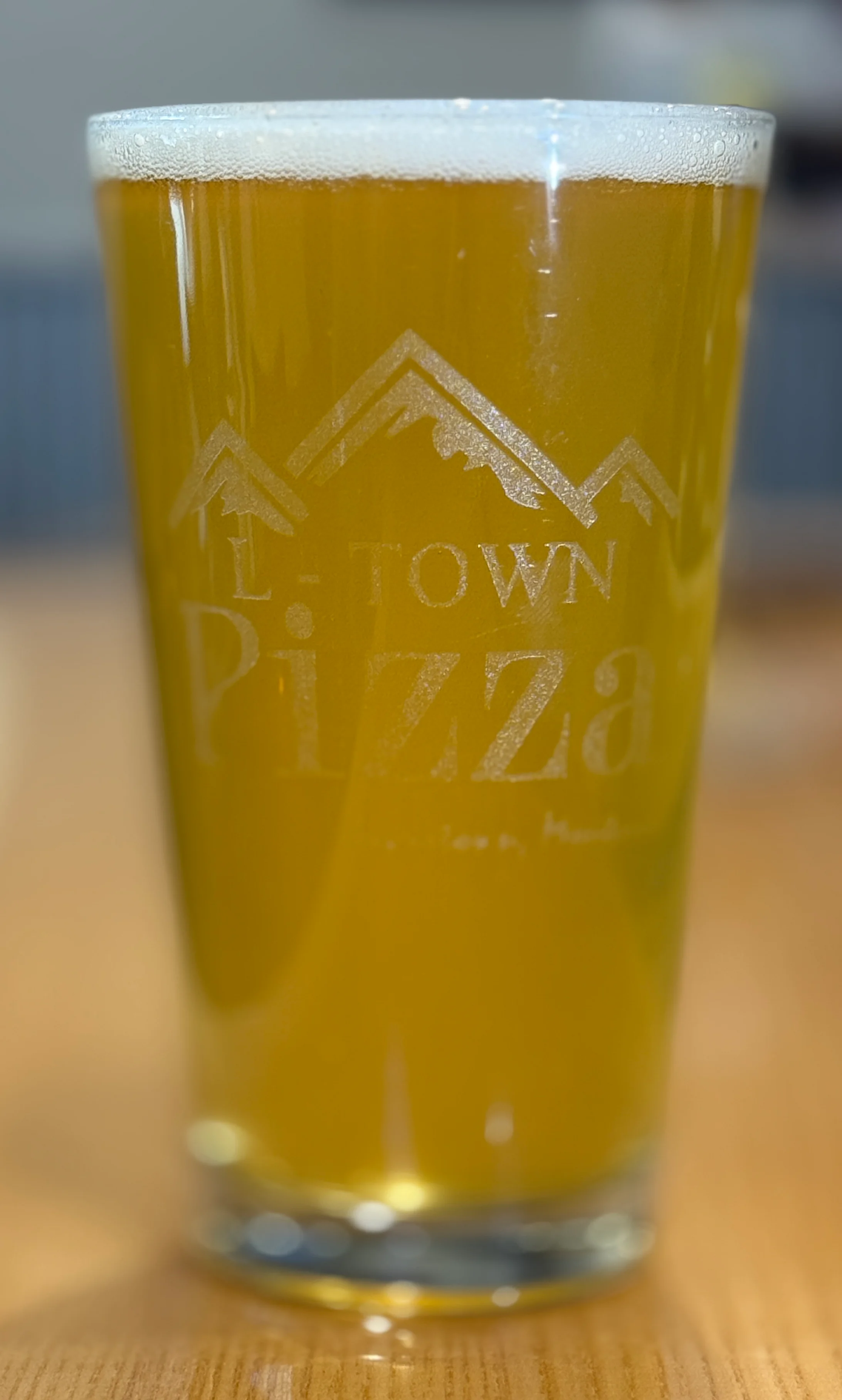 Craft beer in a branded glass at a cozy pizzeria