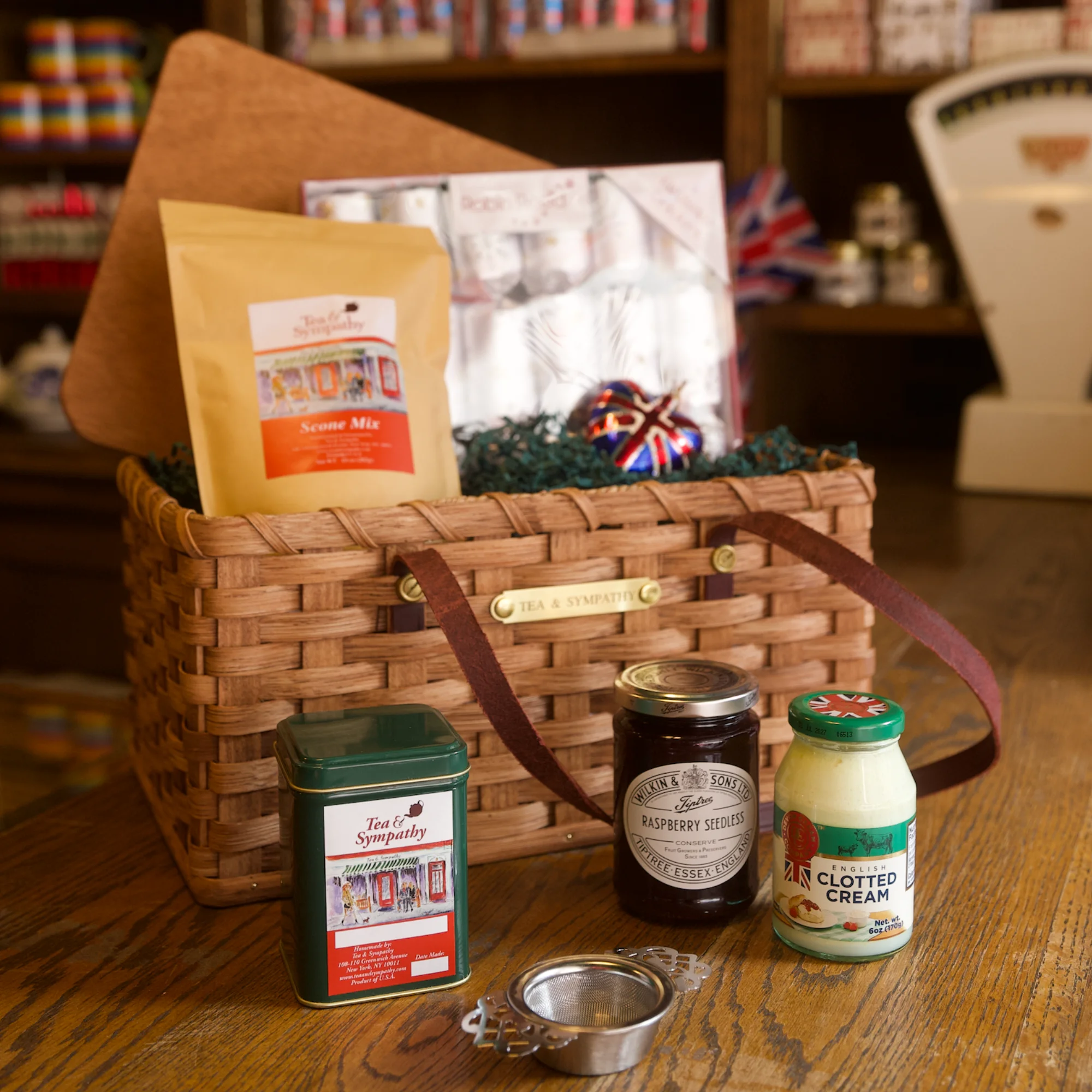 English tea gift basket with tea, raspberry preserve, clotted cream, and strainer