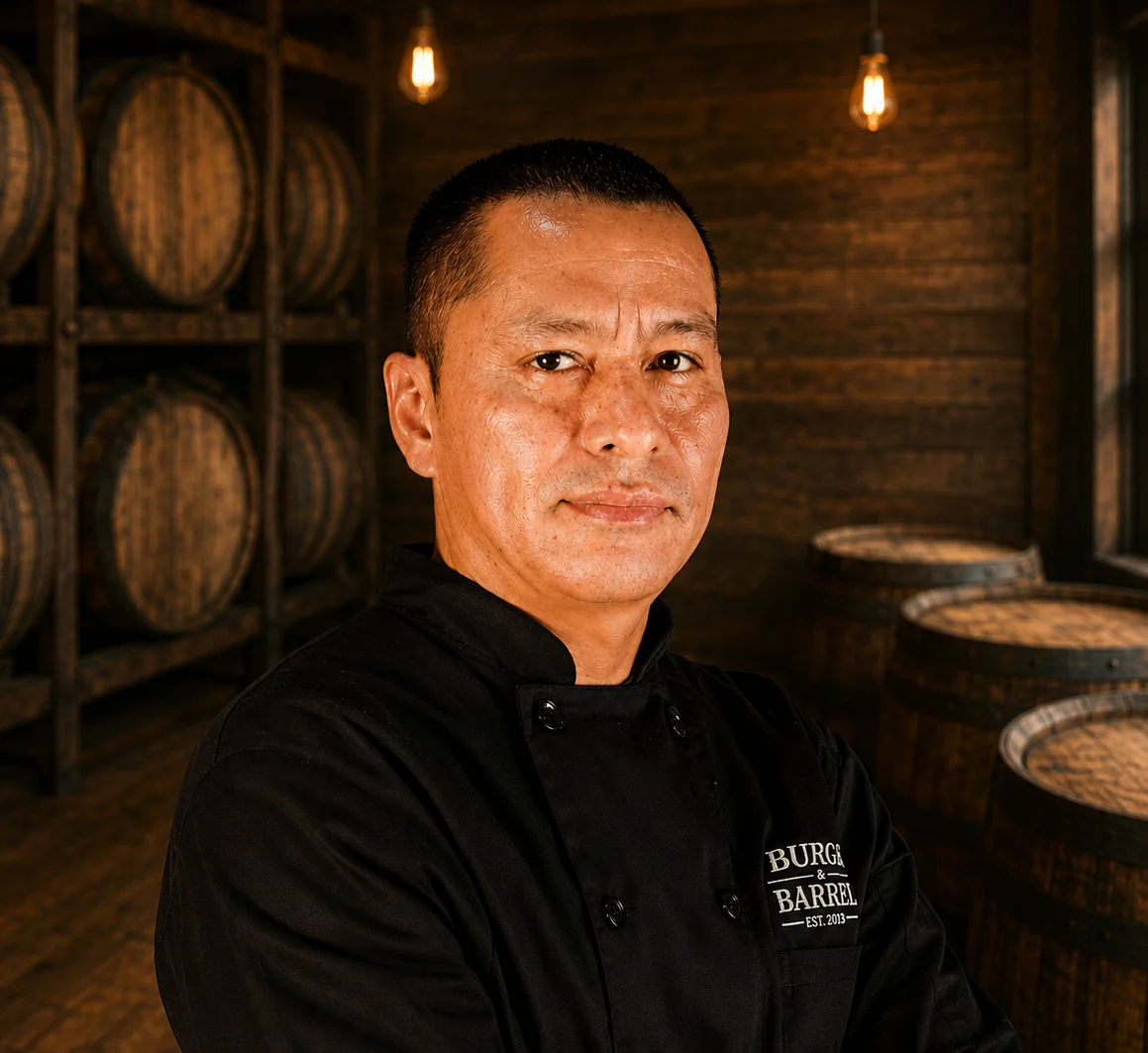 Smiling man in a restaurant with barrels in the background