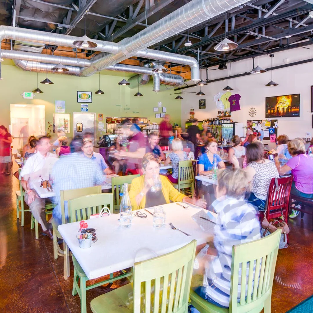 Busy restaurant interior with colorful chairs and lively atmosphere