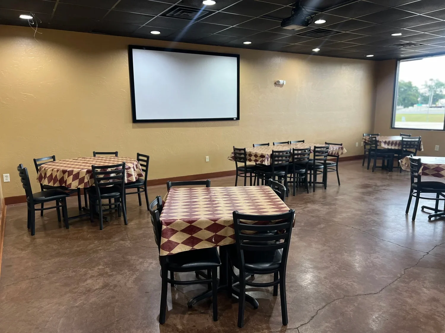 Cozy restaurant interior with tables and projector screen