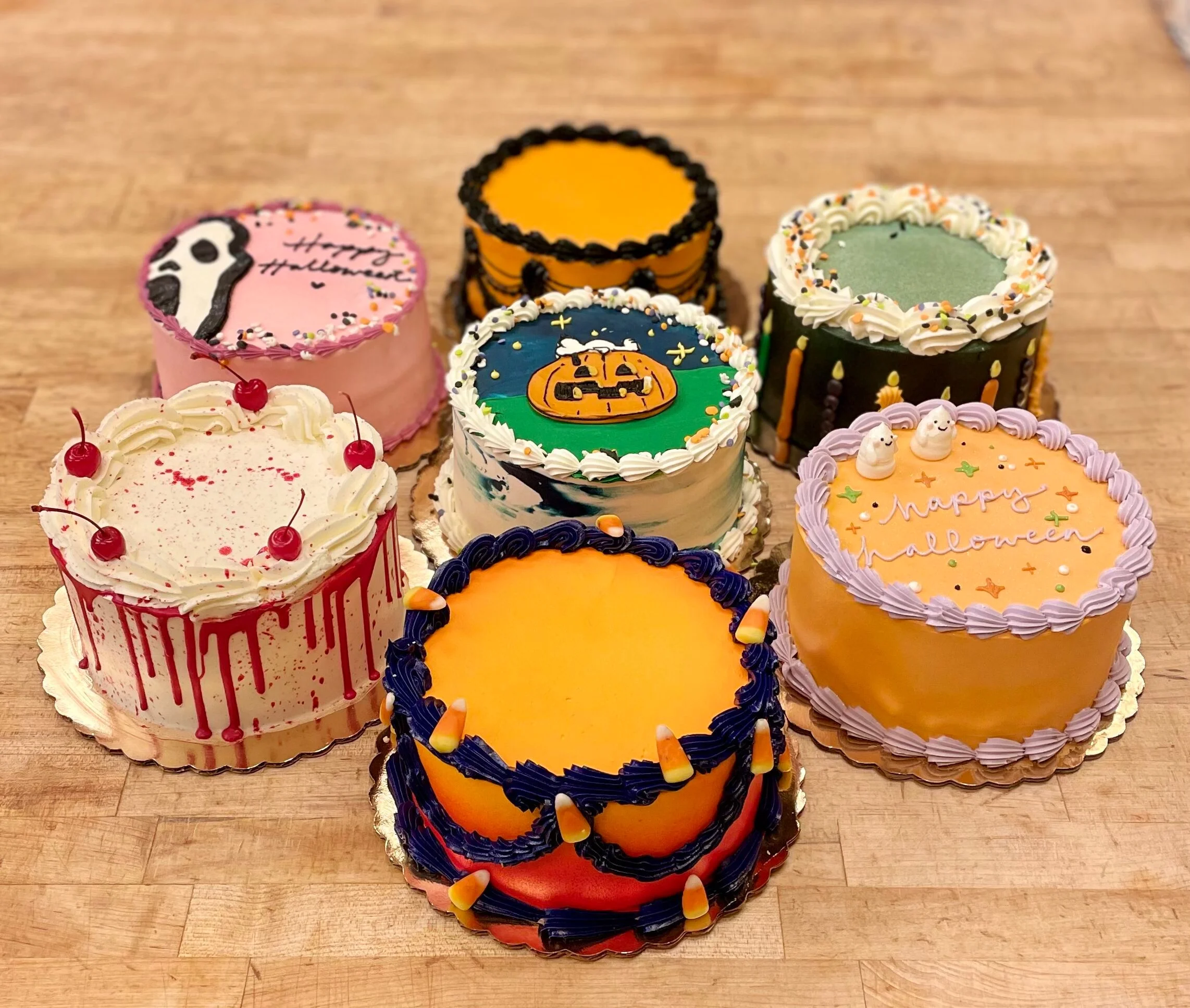 Colorful Halloween-themed decorated cakes with pumpkins, ghosts, and festive frosting