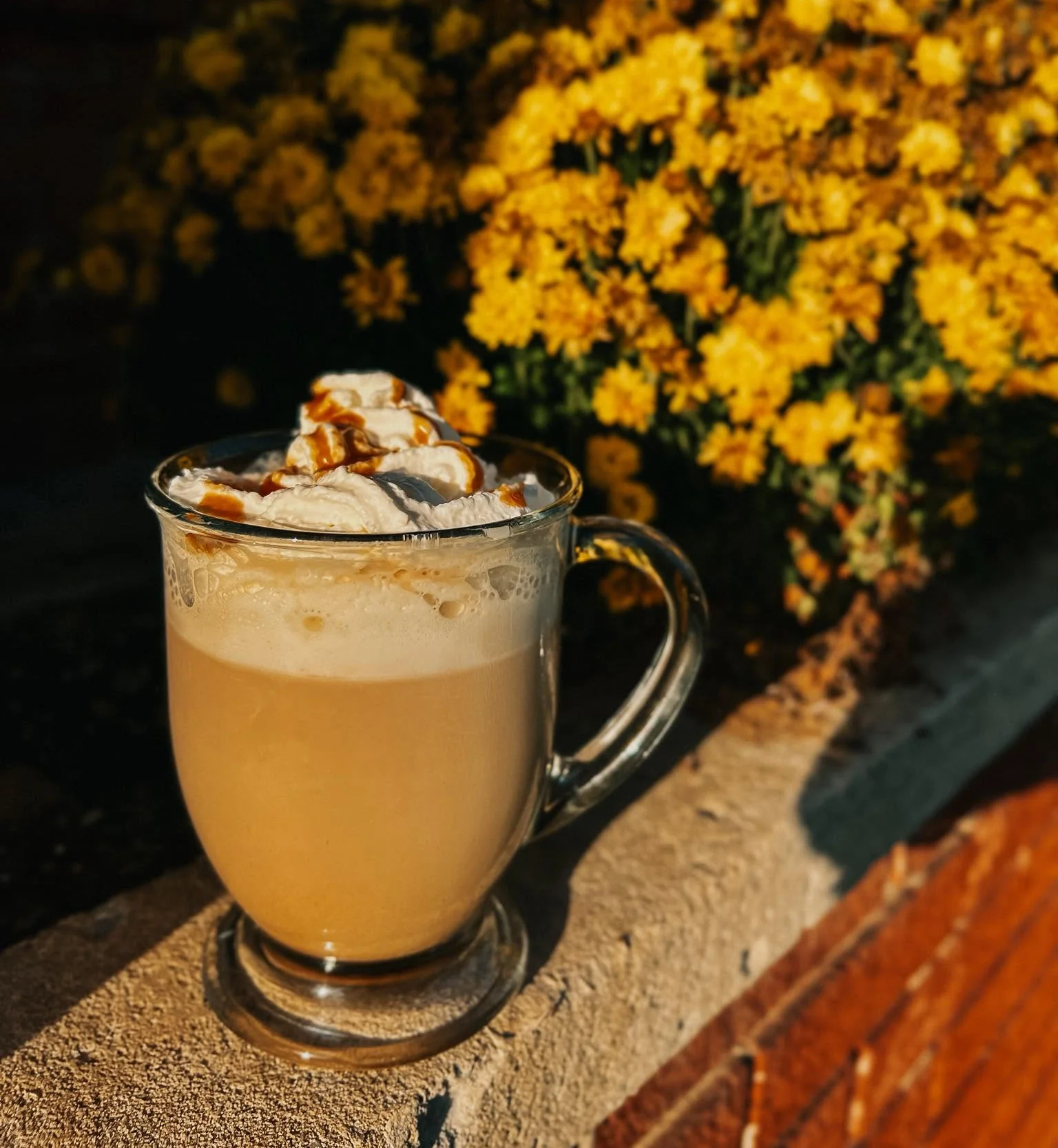Espresso is being brewed into a glass cup from a coffee machine, showcasing the rich color of the coffee.