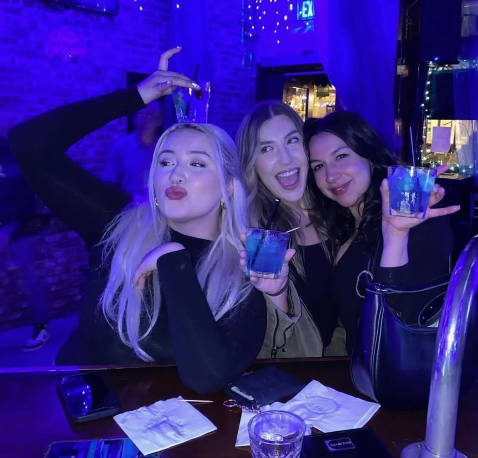 Friends enjoying colorful cocktails in a vibrant bar atmosphere