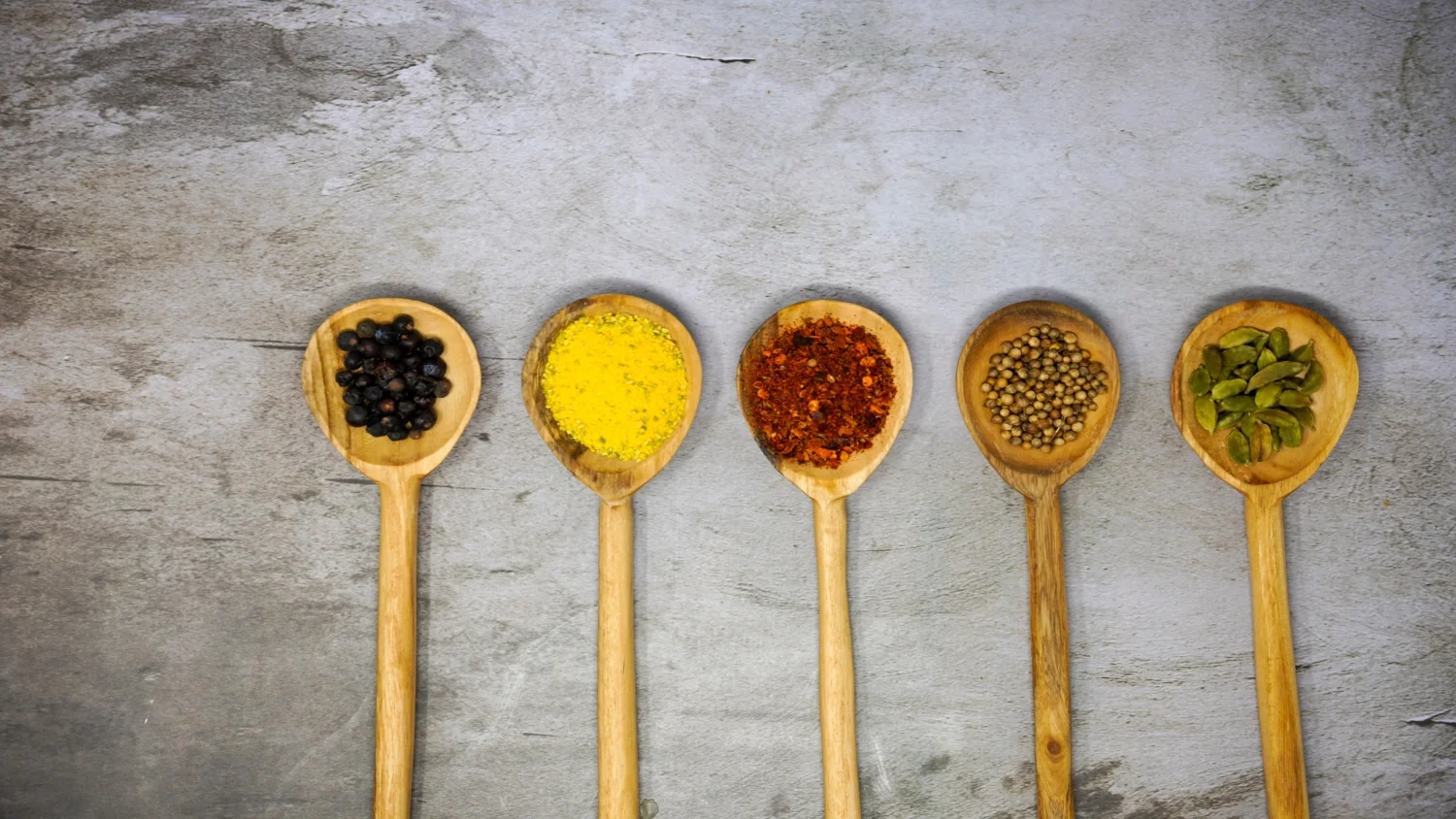 Assorted spices in wooden spoons for Indian cuisine