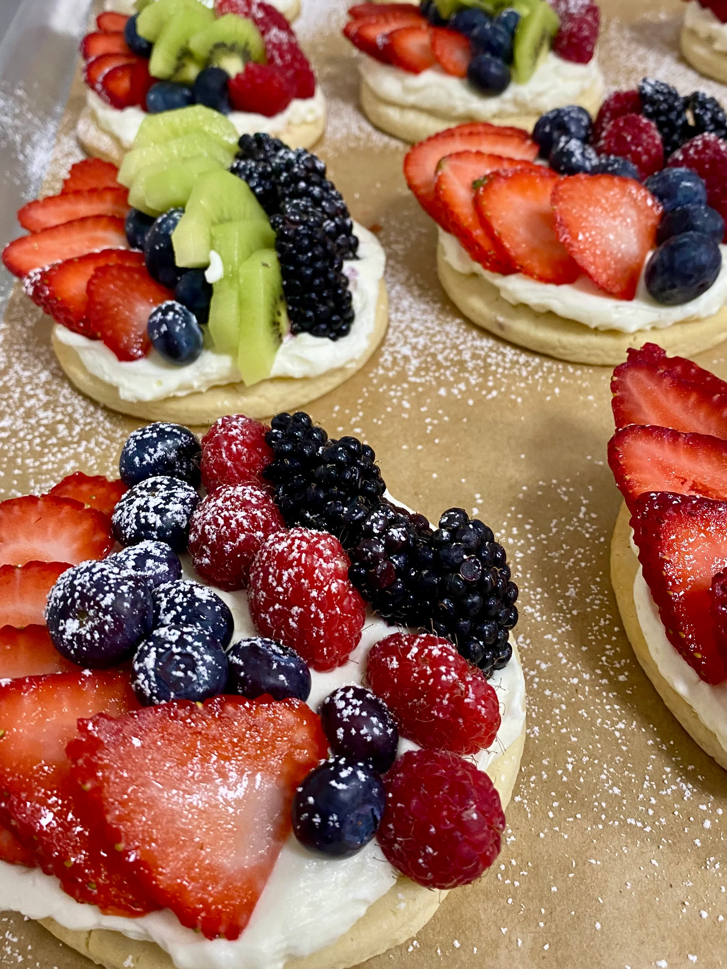 Colorful fruit tarts with cream and fresh berries
