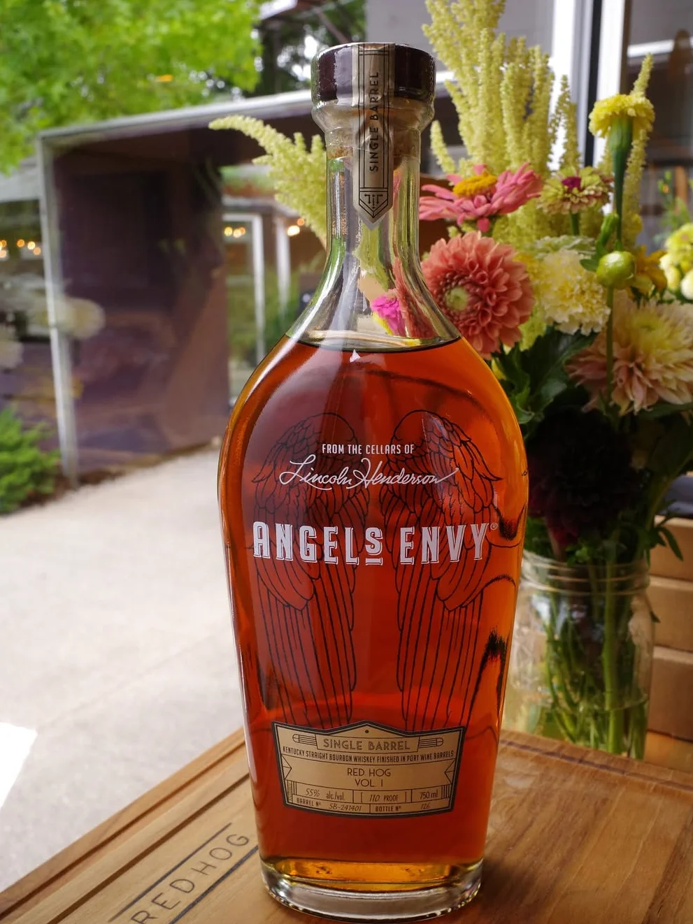 Single barrel bourbon whiskey bottle with a glass and ice.