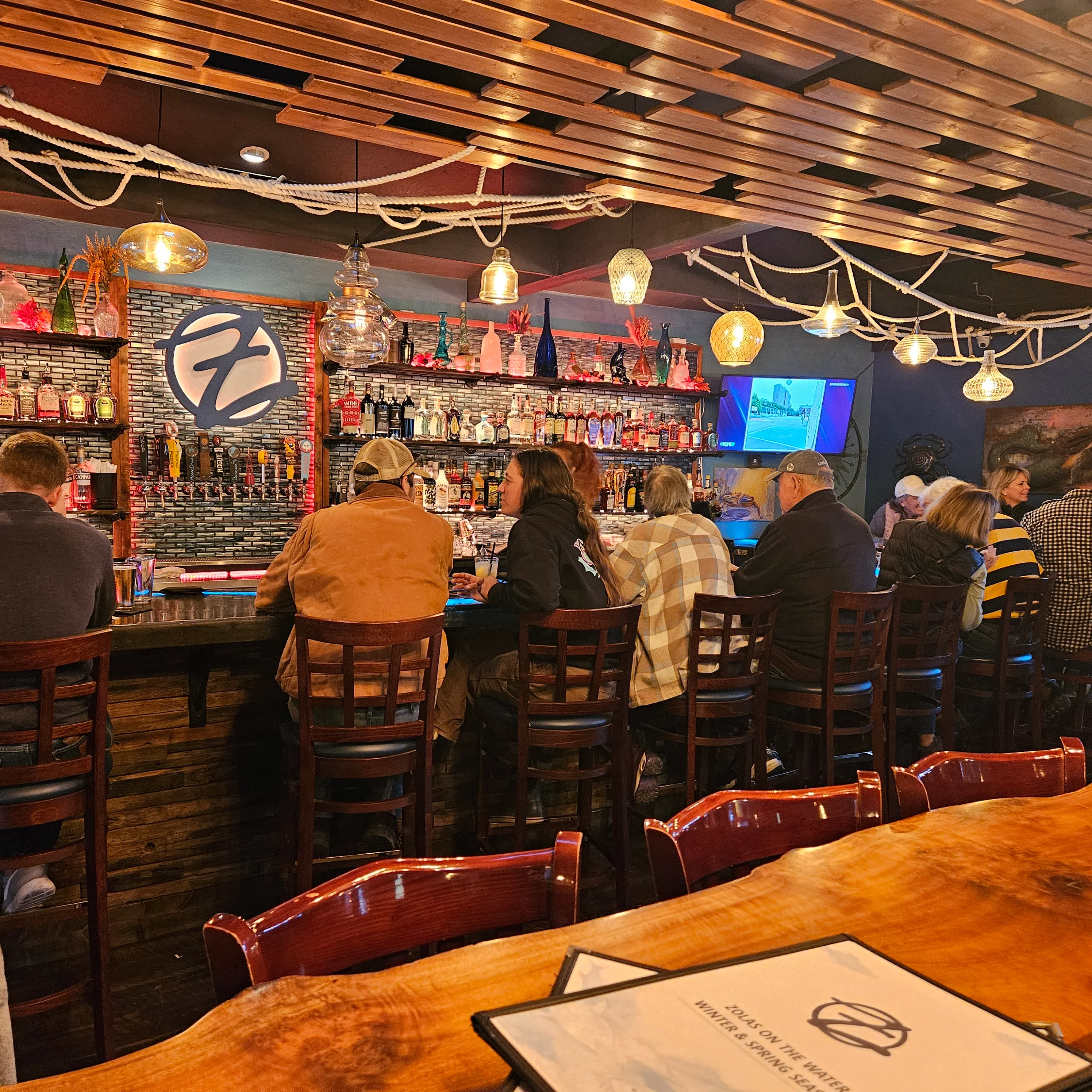 Cozy bar interior with patrons enjoying drinks and warm lighting