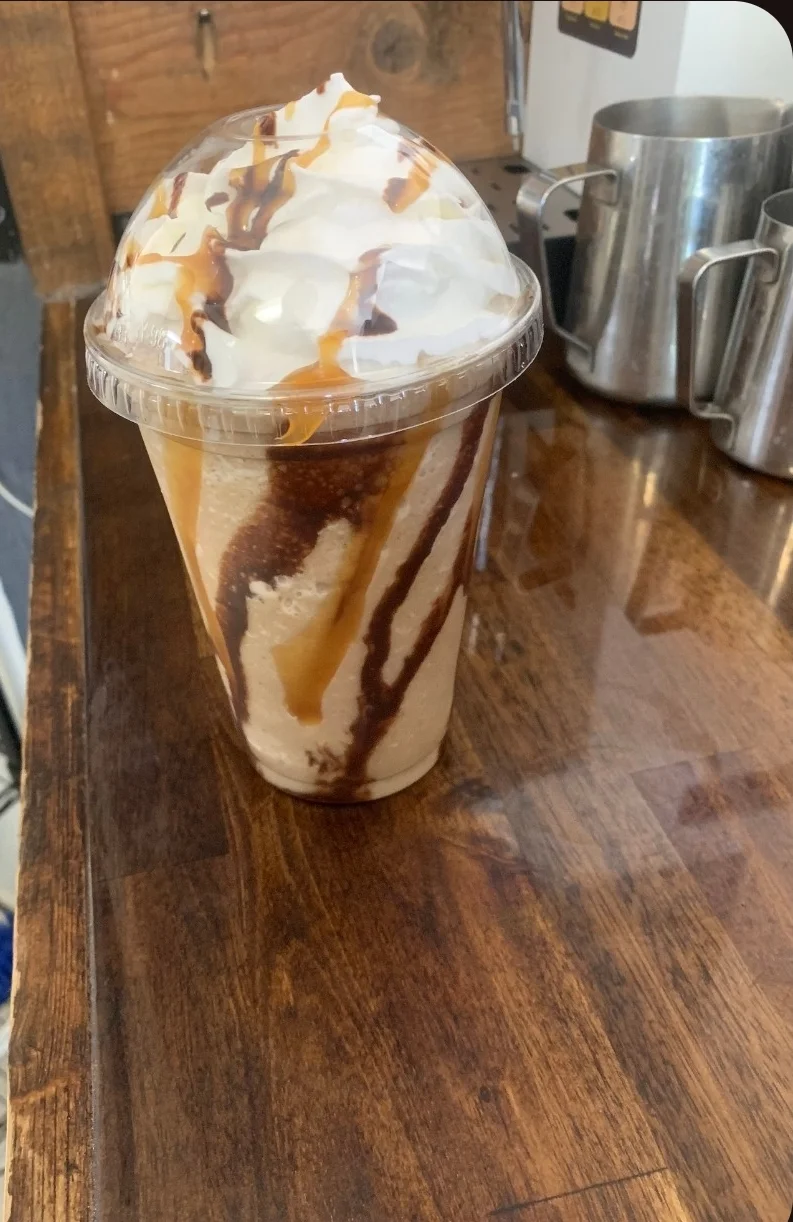 Frappe coffee topped with whipped cream and chocolate drizzle