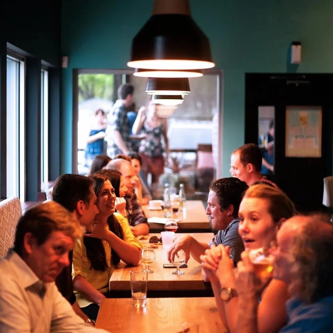 Cozy restaurant interior with diners enjoying conversation and drinks