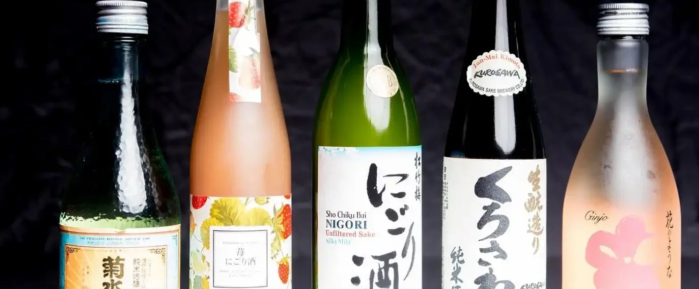 Selection of Japanese sake bottles on a dark background