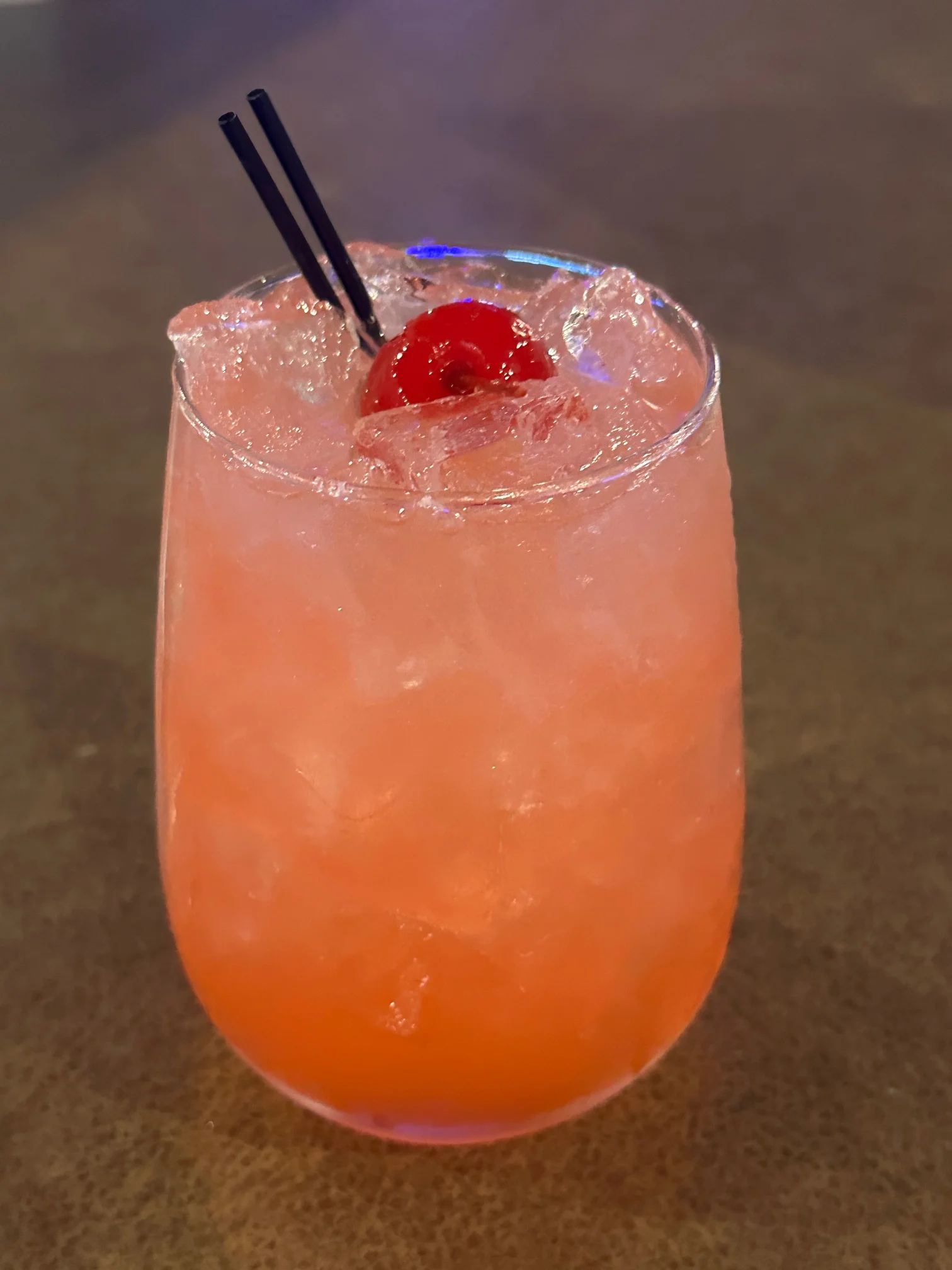 A vibrant cocktail named Chuck's Punch served in a glass with fruit garnishes.