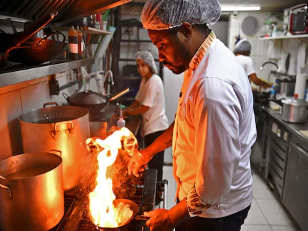 Tolex African Grill Chef making Suya over fire in kitchen