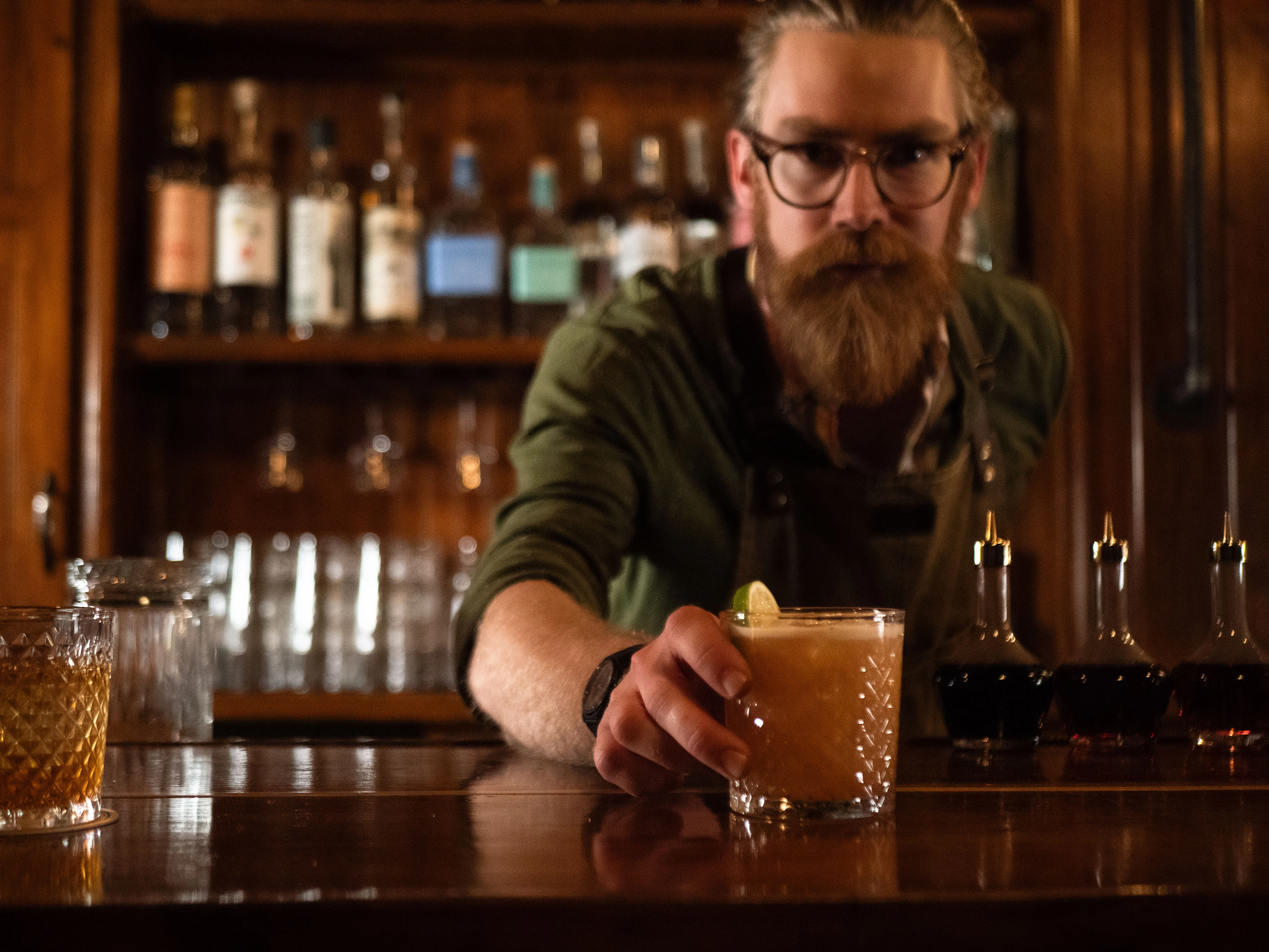 Nate placing a cocktail on the bar
