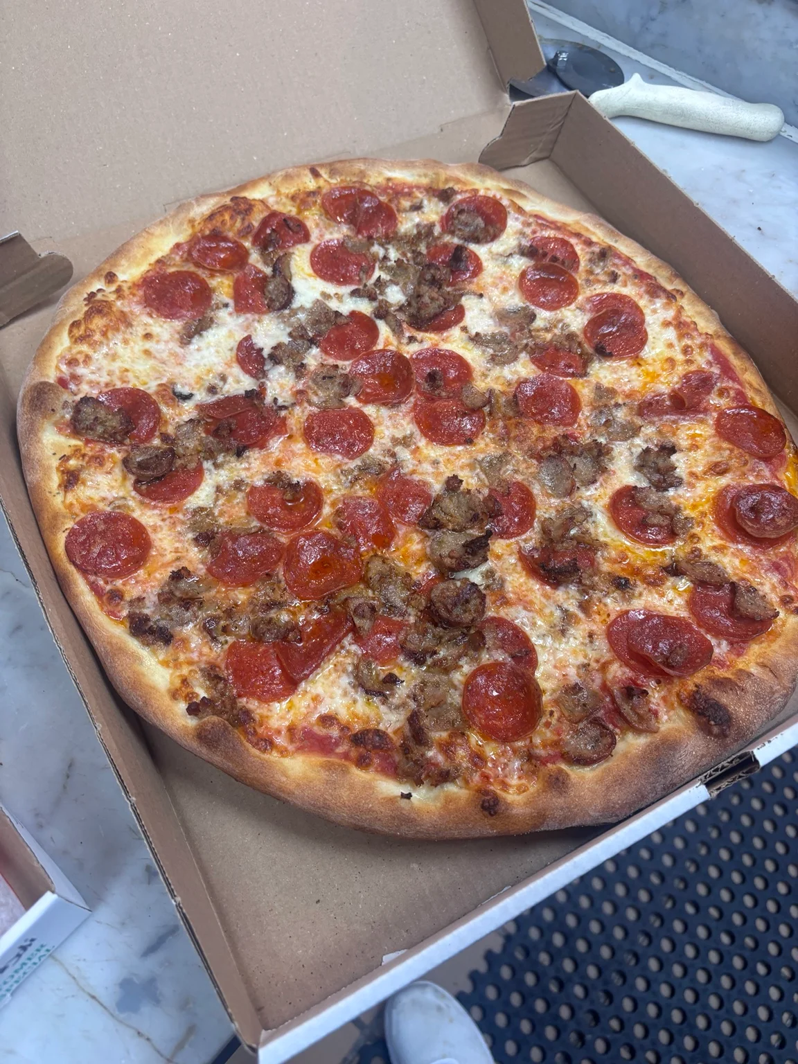 Pasquale’s pizza topped with pepperoni and meat in a takeout box
