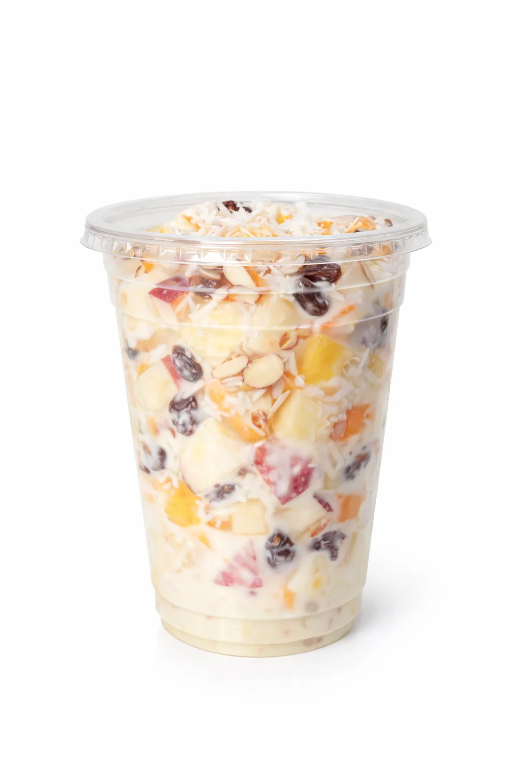 A layered dessert cup containing a mix of fruits, nuts, and a creamy dressing, topped with shredded coconut.