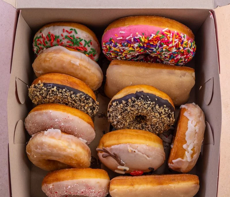 Assorted colorful donuts in a box, perfect for sharing or celebrations